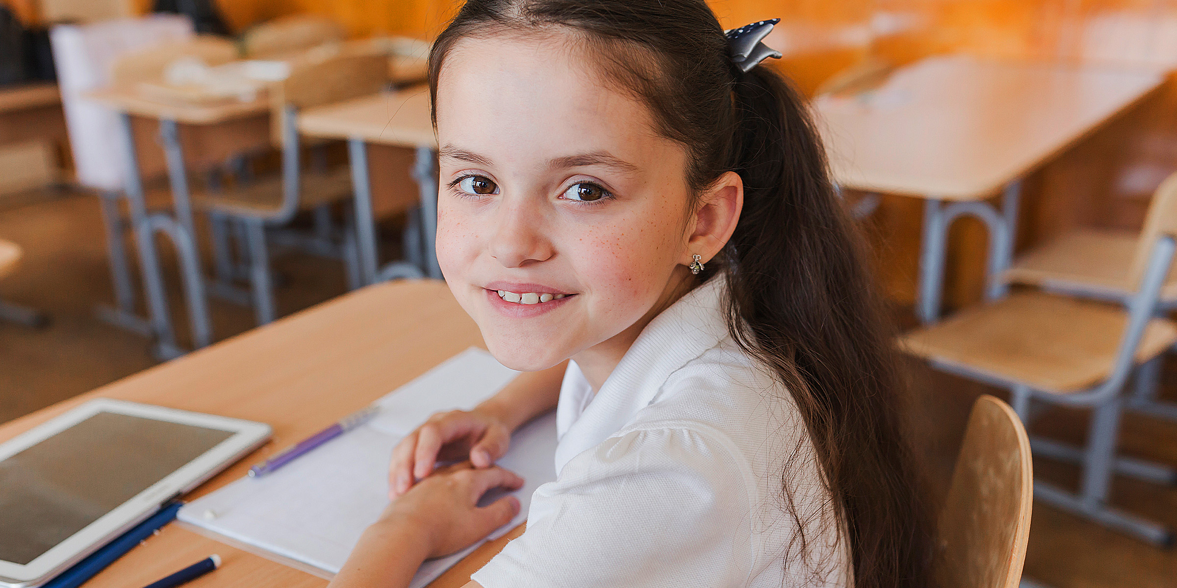 A happy girl in a classroom | Source: Freepik