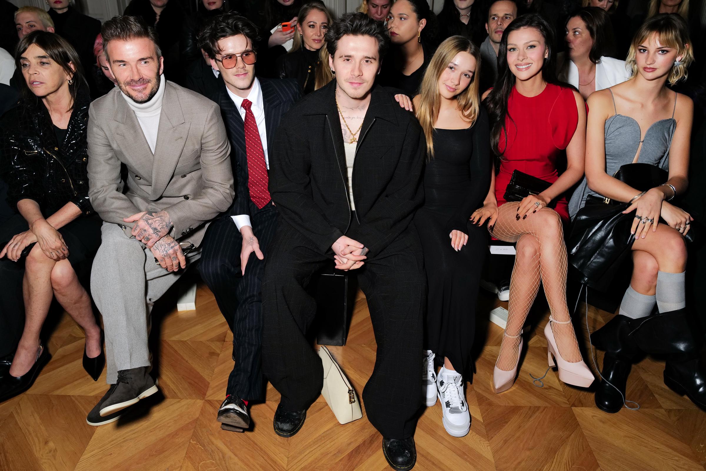 Carine Roitfeld, David Beckham, Cruz Beckham, Brooklyn Peltz Beckham, Harper Beckham, Nicola Peltz Beckham and Mia Regan attend the Victoria Beckham AW24 show during Paris Fashion Week on March 01, 2024 in Paris, France. | Source: Getty Images