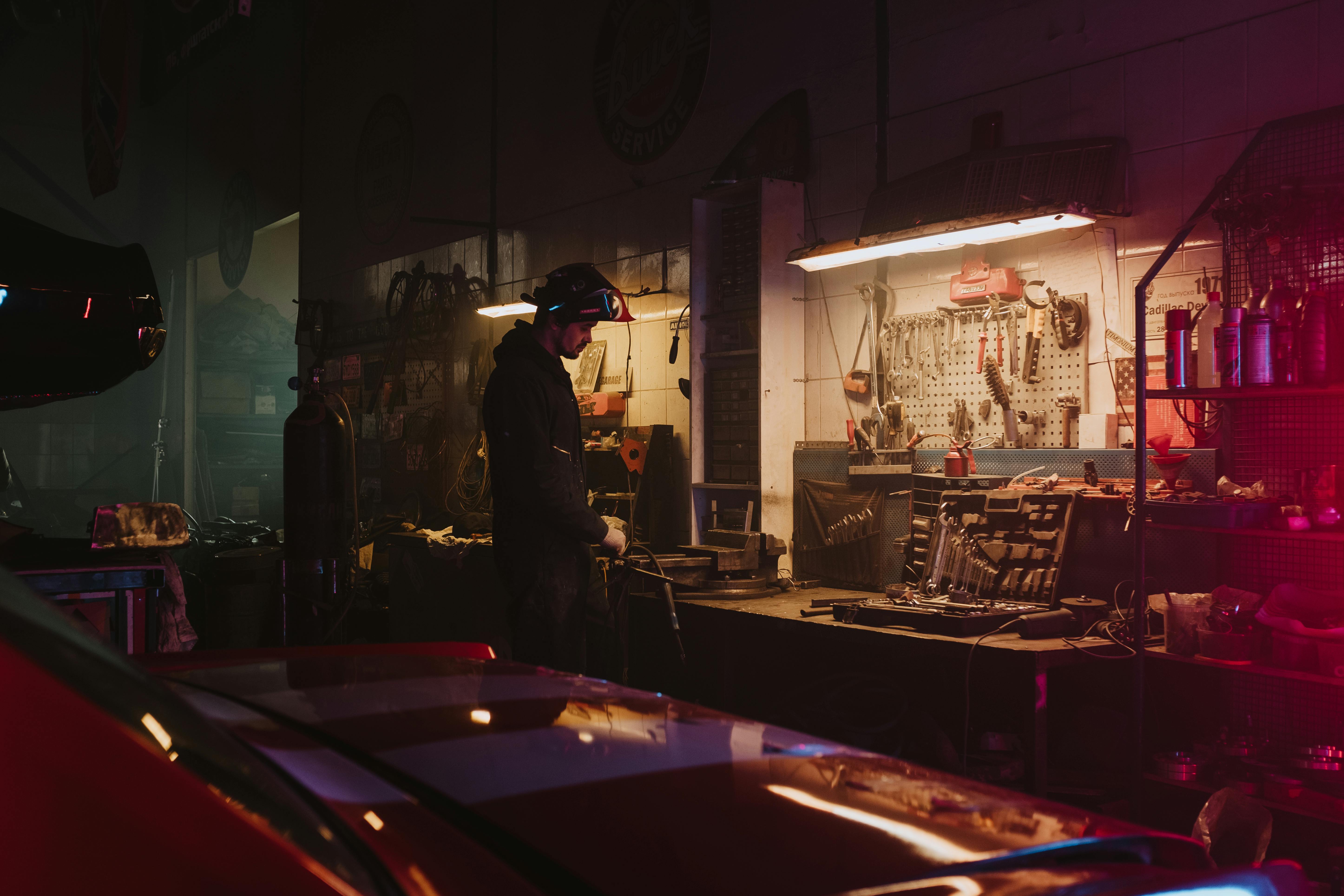 A man standing in a car body shop | Source: Pexels
