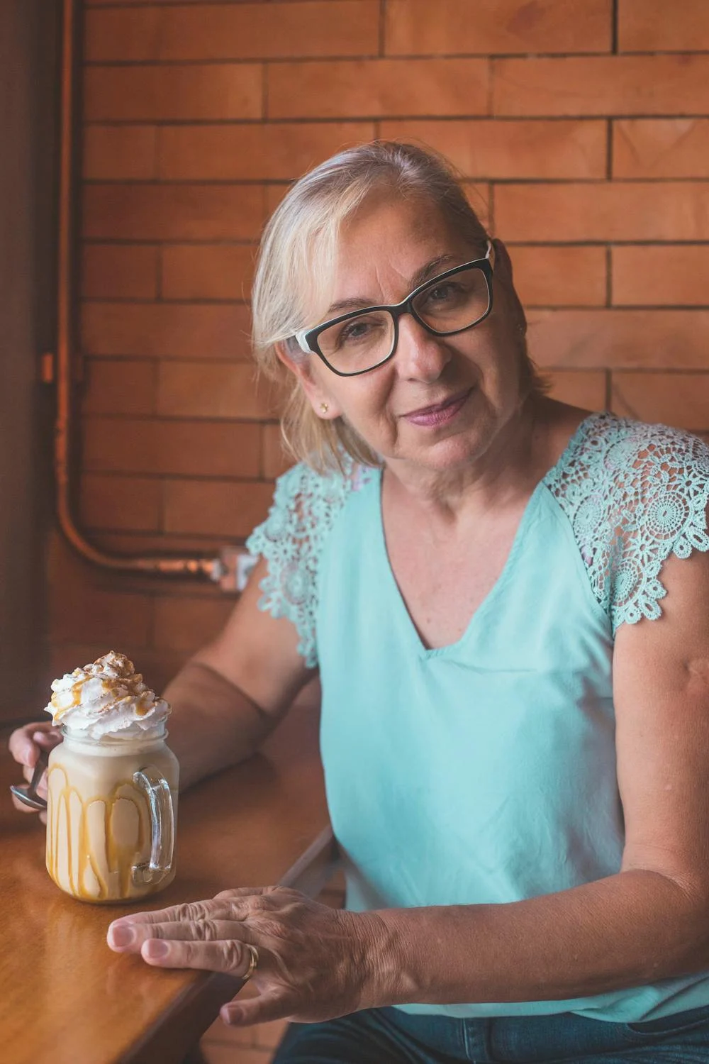 A smiling woman drinking coffee ⏐ Source: Pexels