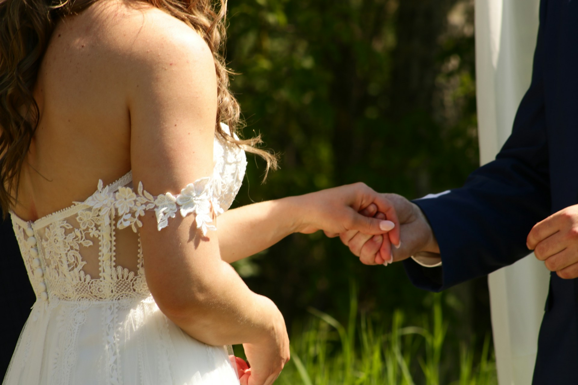 Cropped shot of a groom holding a bride's hand | Source: Unsplash