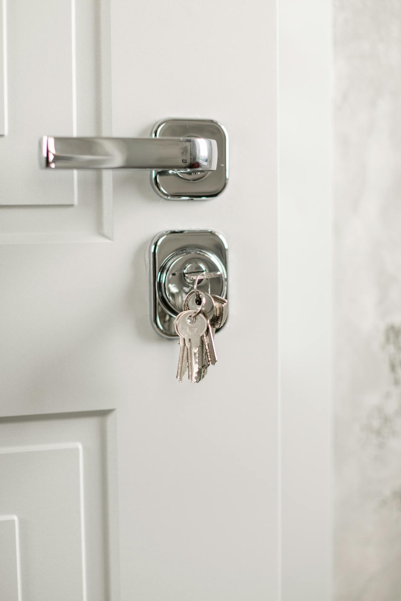 A key inserted in the lock of a white door | Source: Pexels