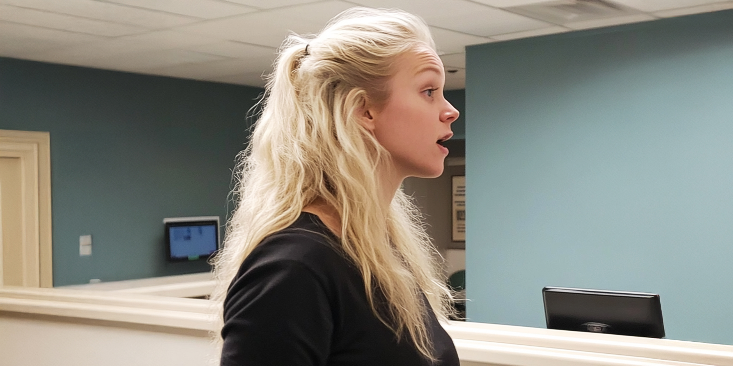 A blonde woman standing in a hospital corridor | Source: Midjourney