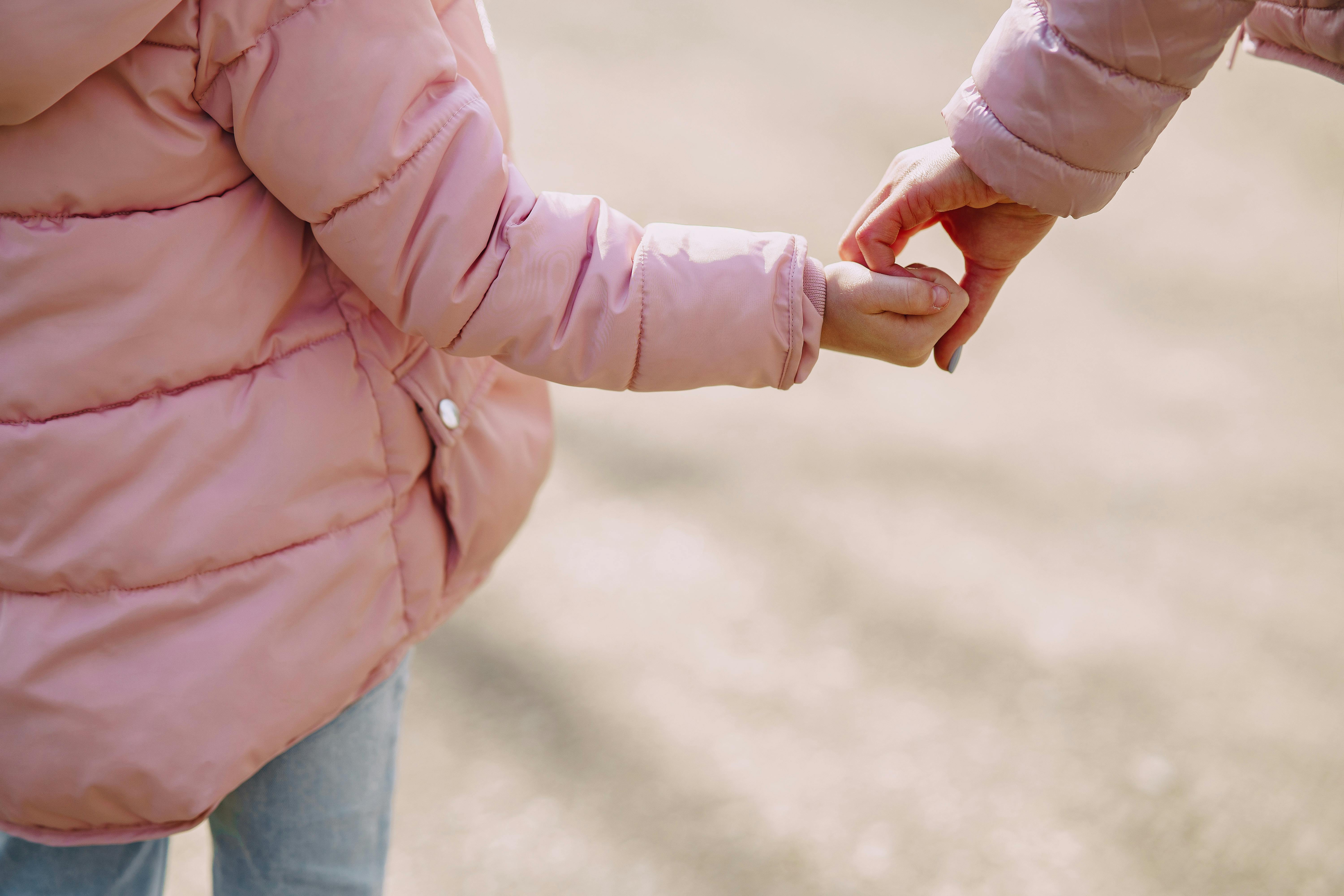 A mother holding her little daughter's hand | Source: Pexels