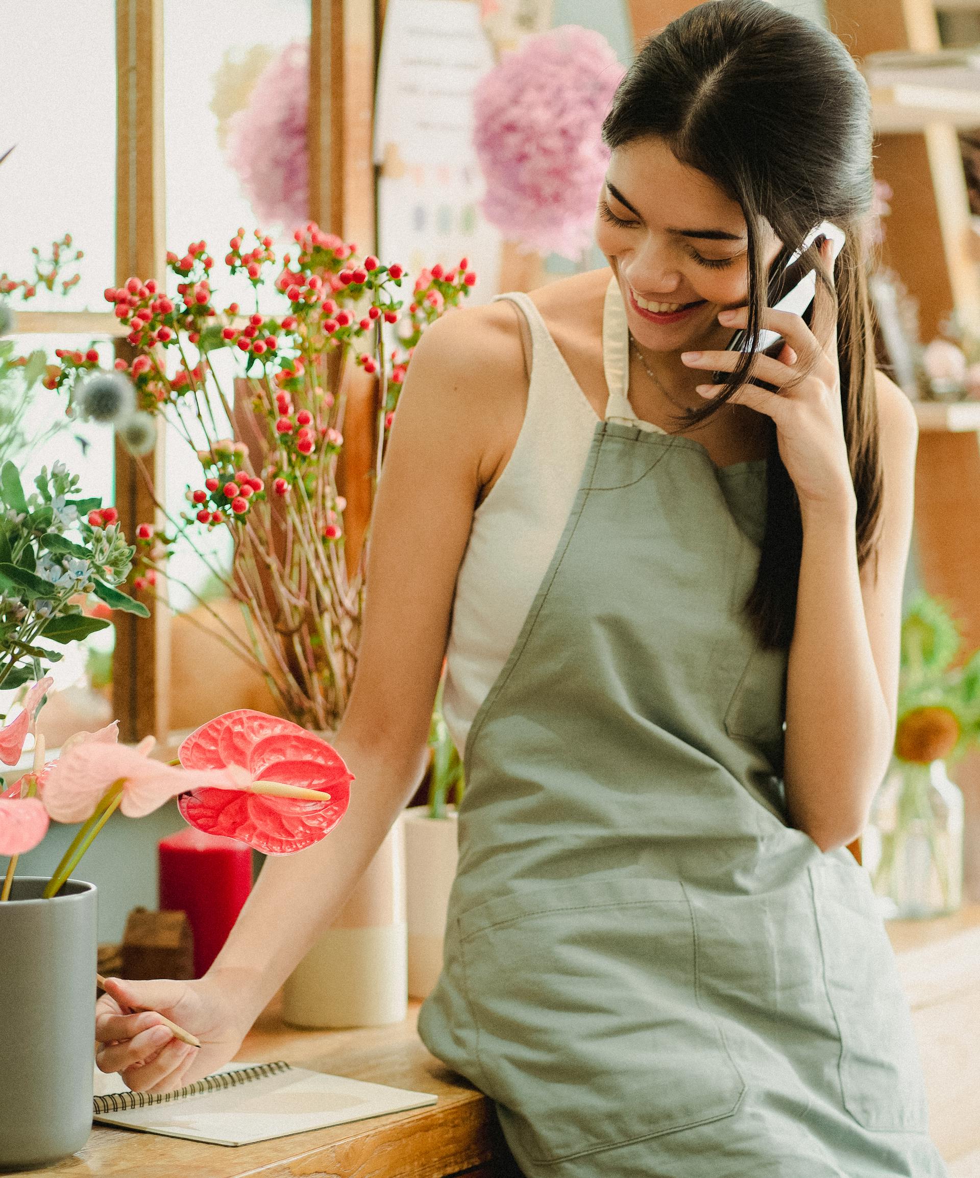 A happy woman in an apron on a call | Source: Pexels