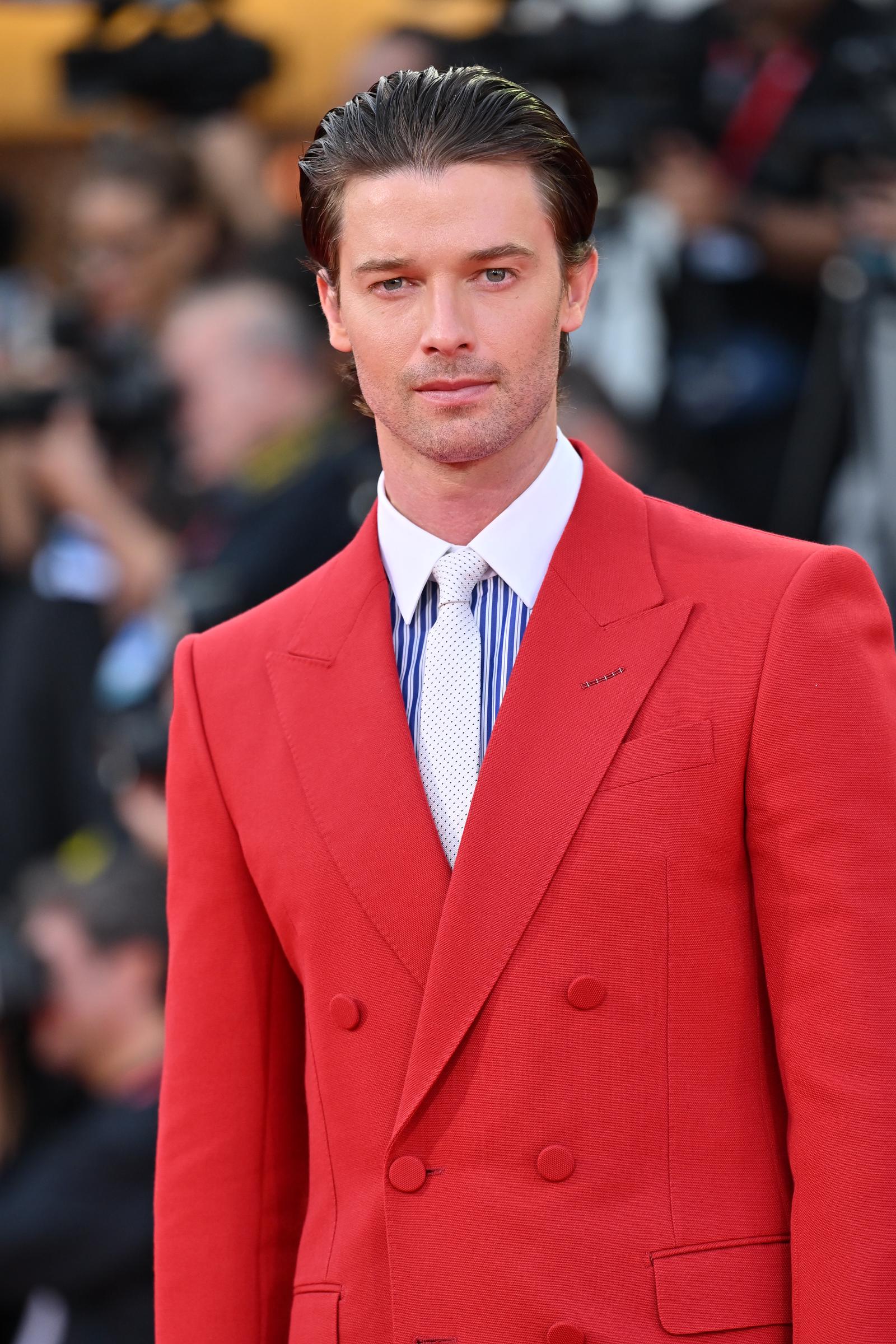 Patrick Schwarzenegger gives a closer look at his bold red tailoring, with slicked-back hair and a patterned light tie adding to the polished look. | Source: Getty Images