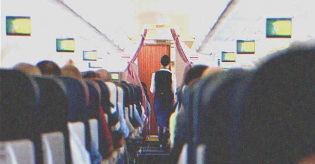 A stewardess walking in plane full of passengers | Source: Shutterstock