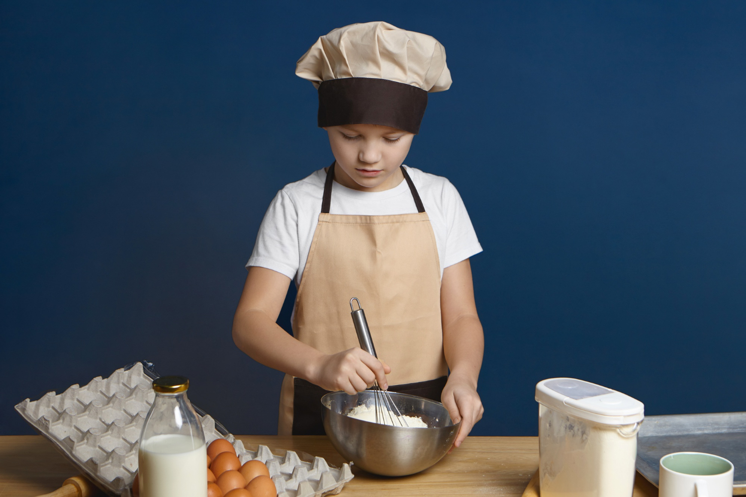 A boy busy baking | Source: Freepik