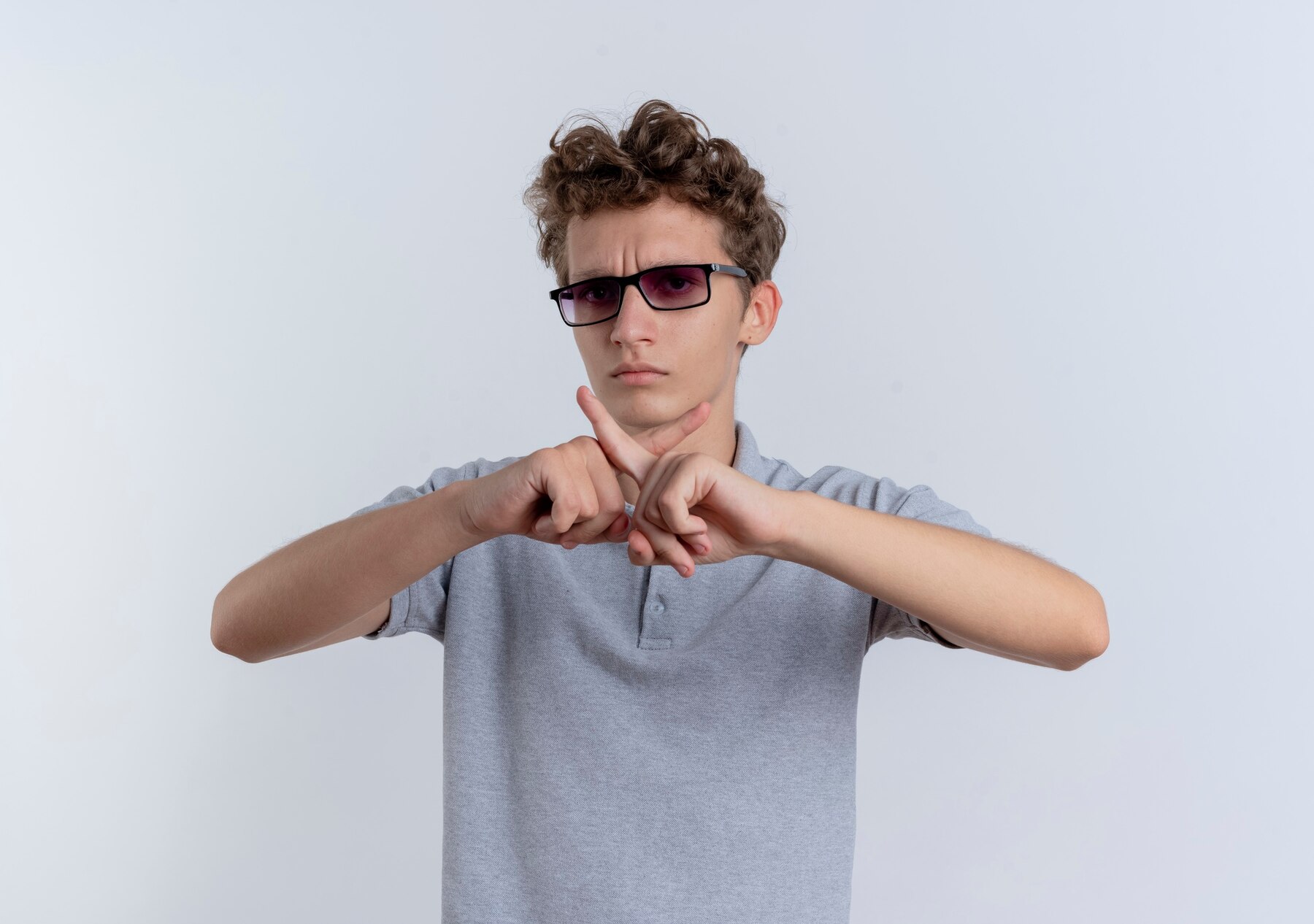 A teenage boy showing a cross | Source: Freepik