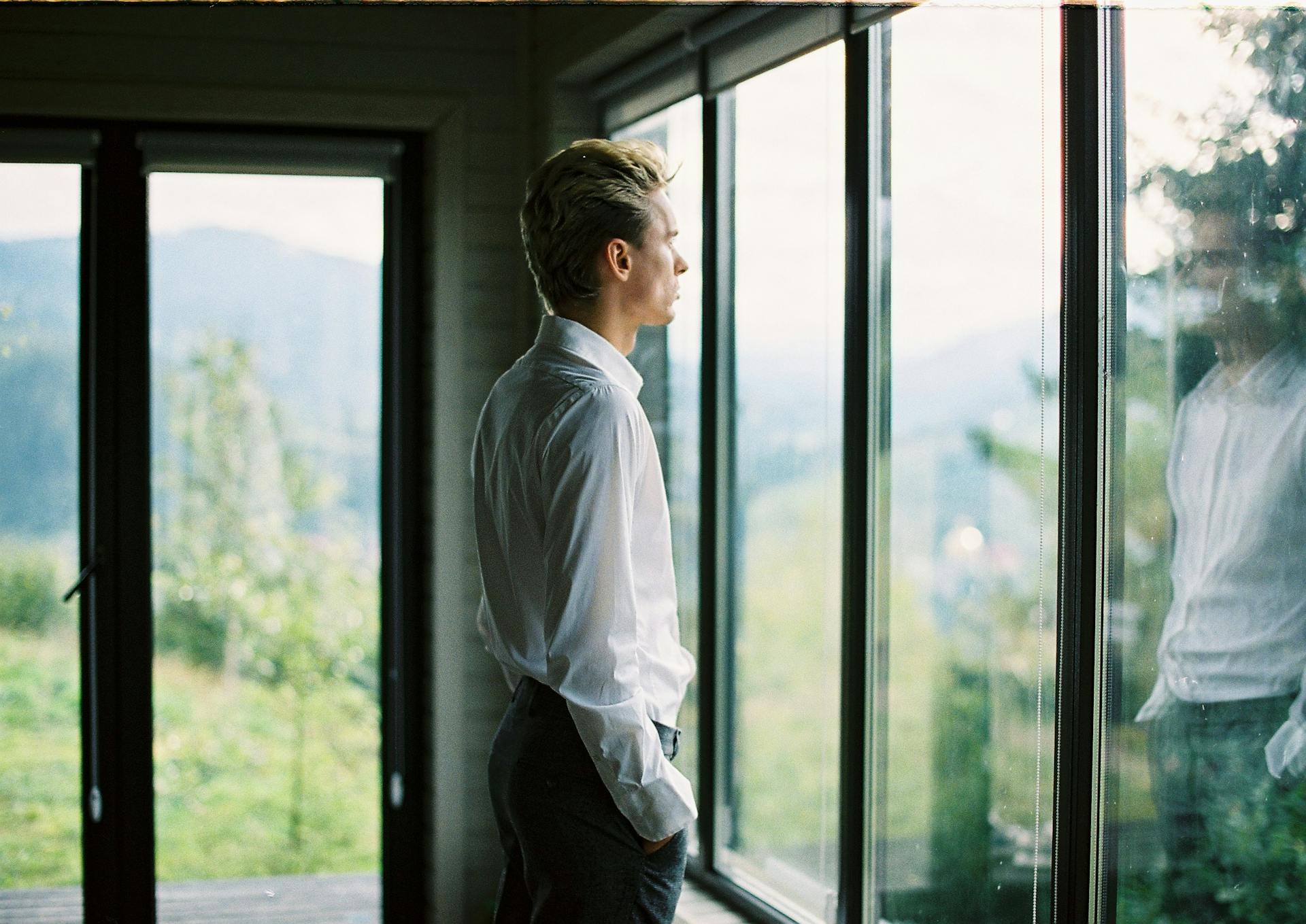 A man standing near a glass window | Source: Pexels