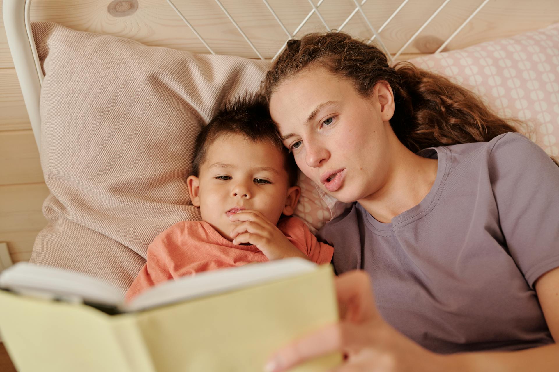 A mother reading her son a book | Source: Pexels