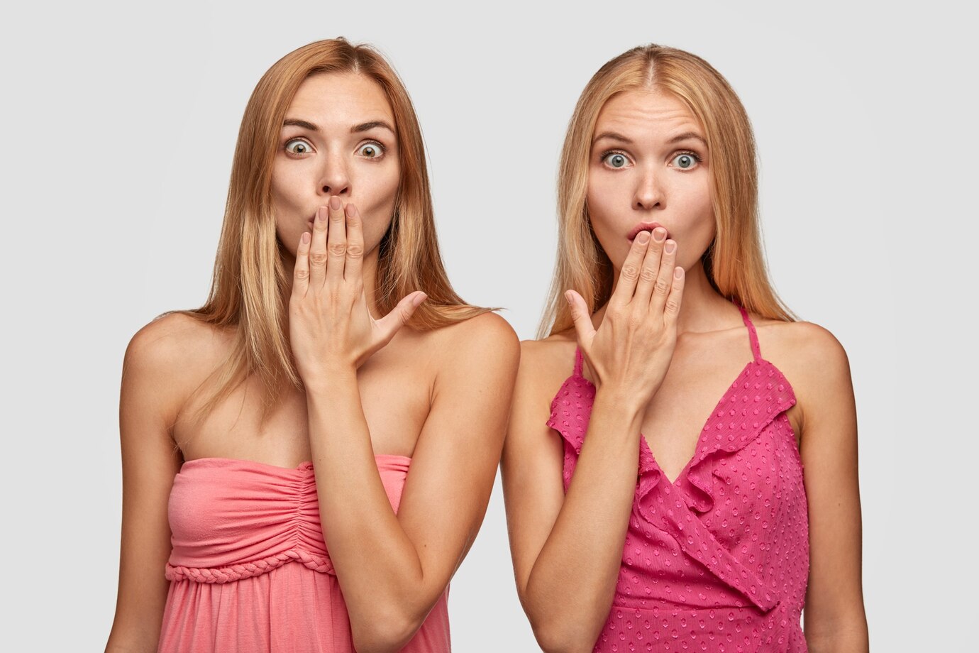 Shocked women in pink dresses | Source: Freepik