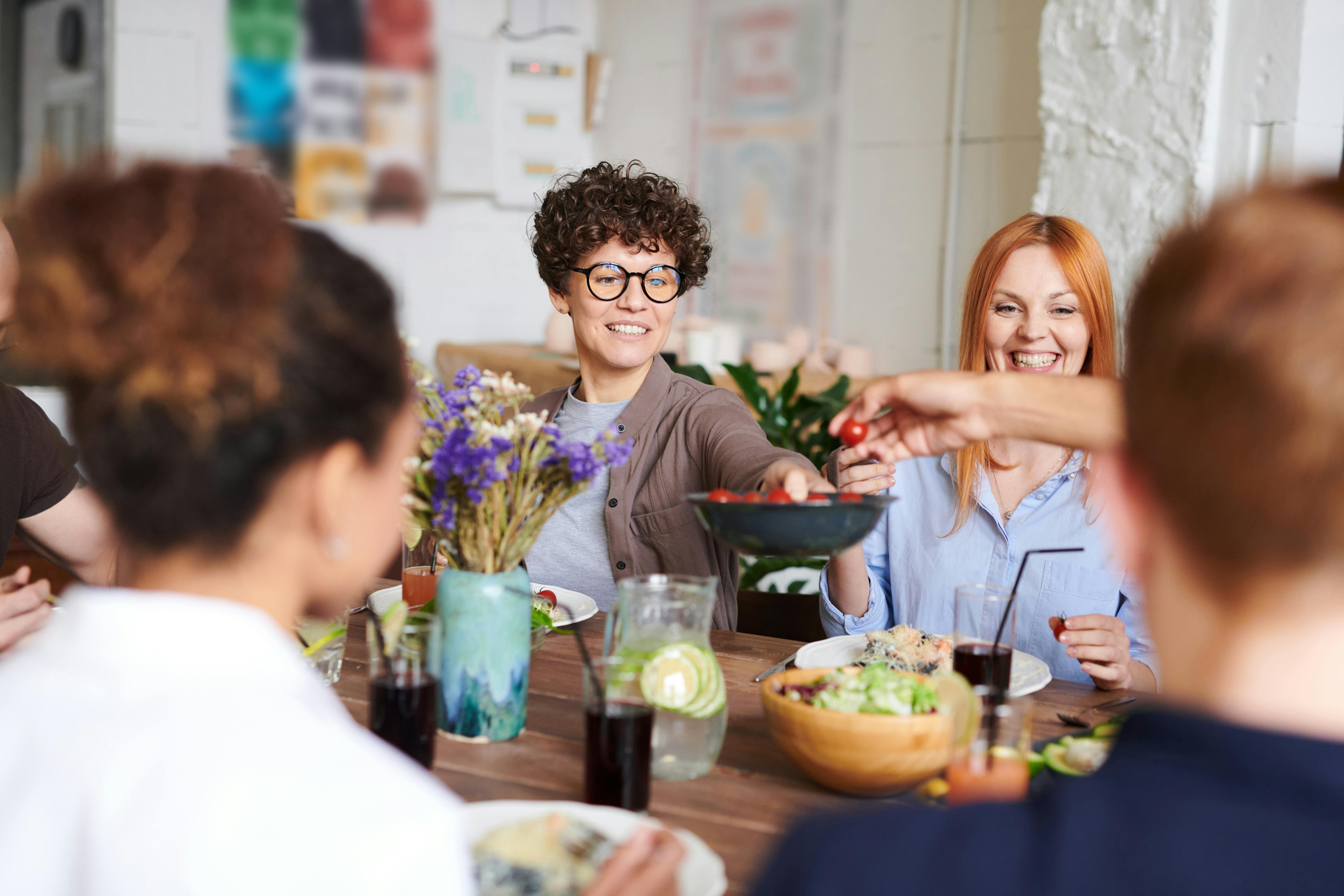 People laughing and sharing food during a party | Source: Pexels
