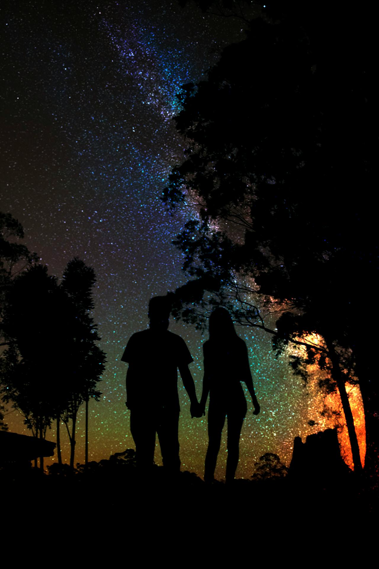 Silhouette d'un couple se tenant la main la nuit | Source : Pexels