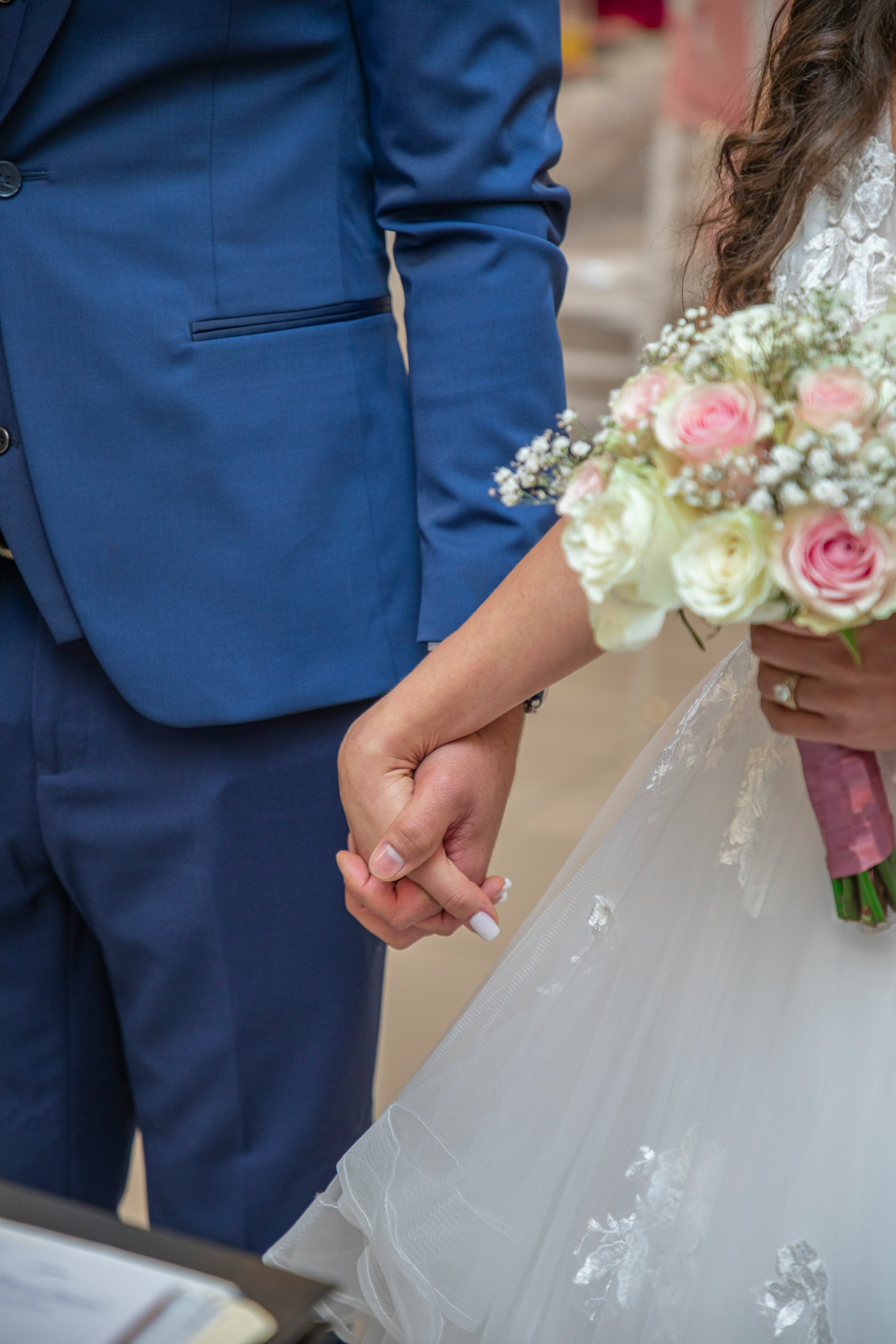 A bride holding her groom's hand during their wedding ceremony | Source: Unsplash