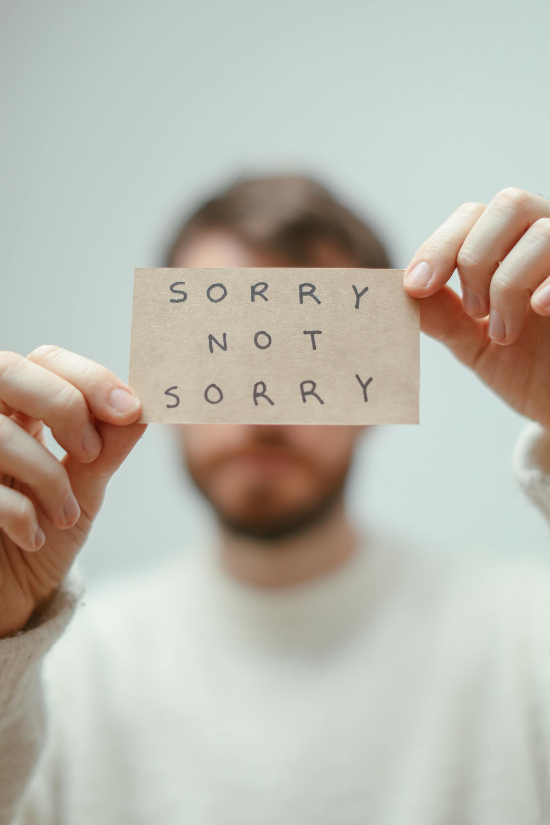 A man holding a paper with a phrase written on it | Source: Pexels
