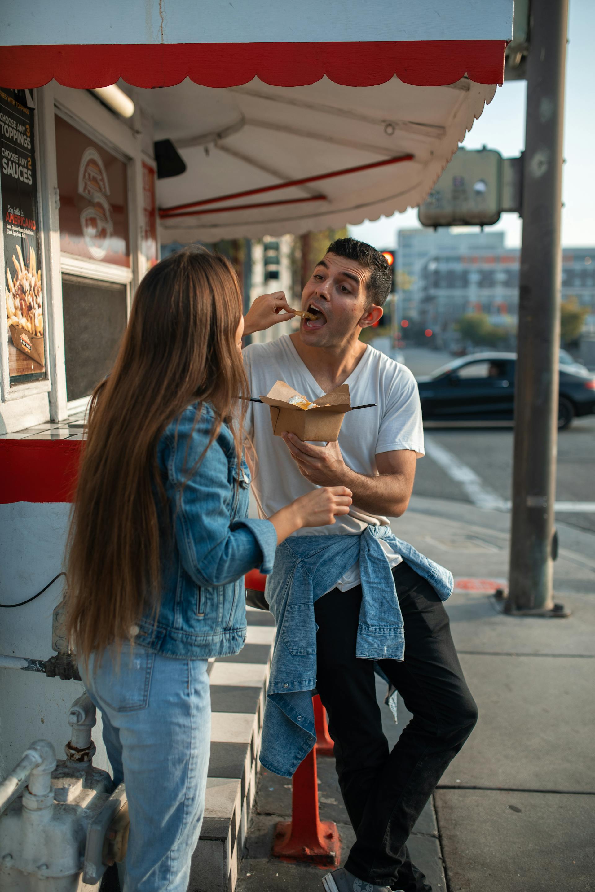 A woman feeding a man holding a takeout box | Source: Pexels