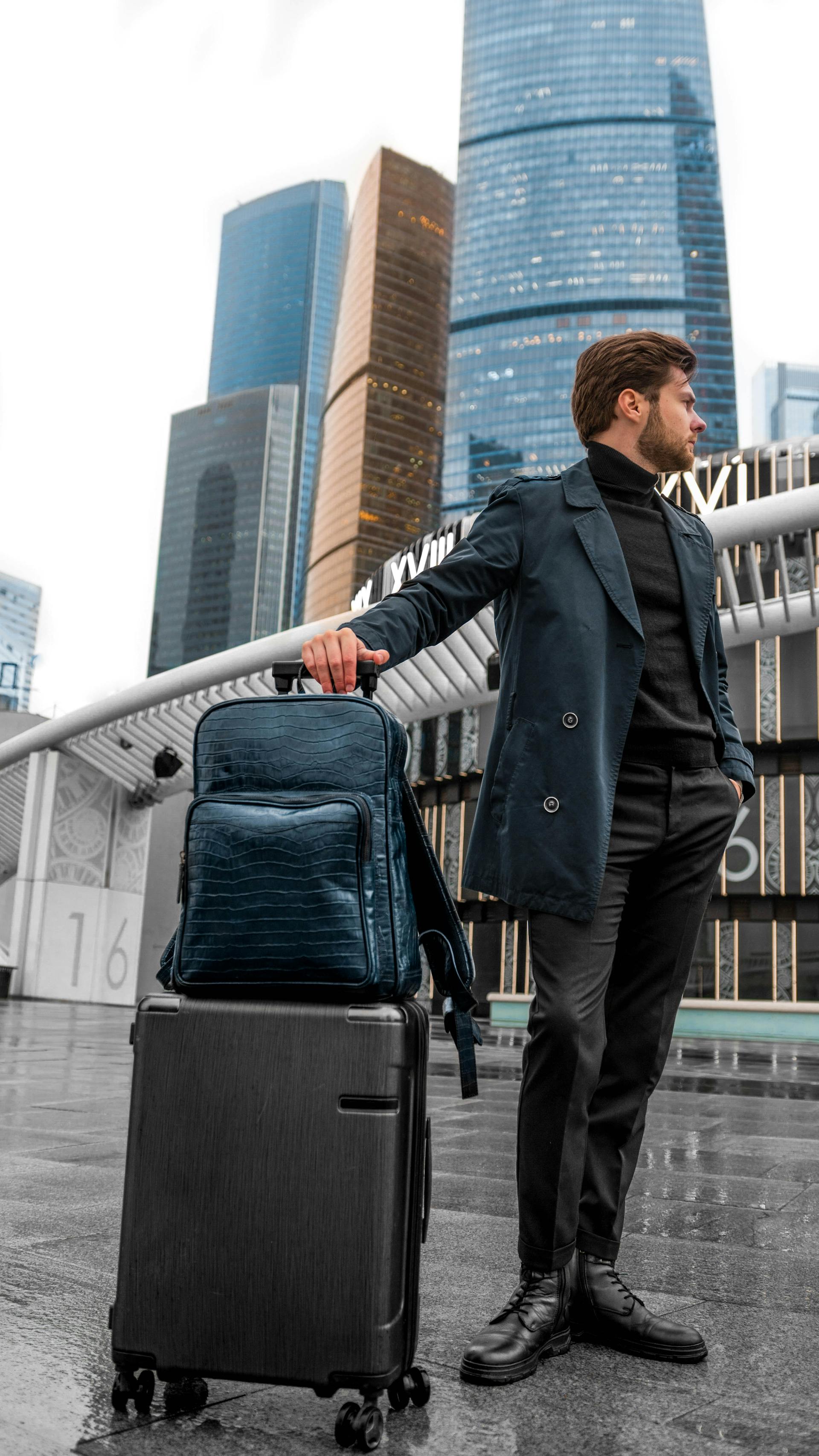Man standing with a backpack and suitcase | Source: Pexels