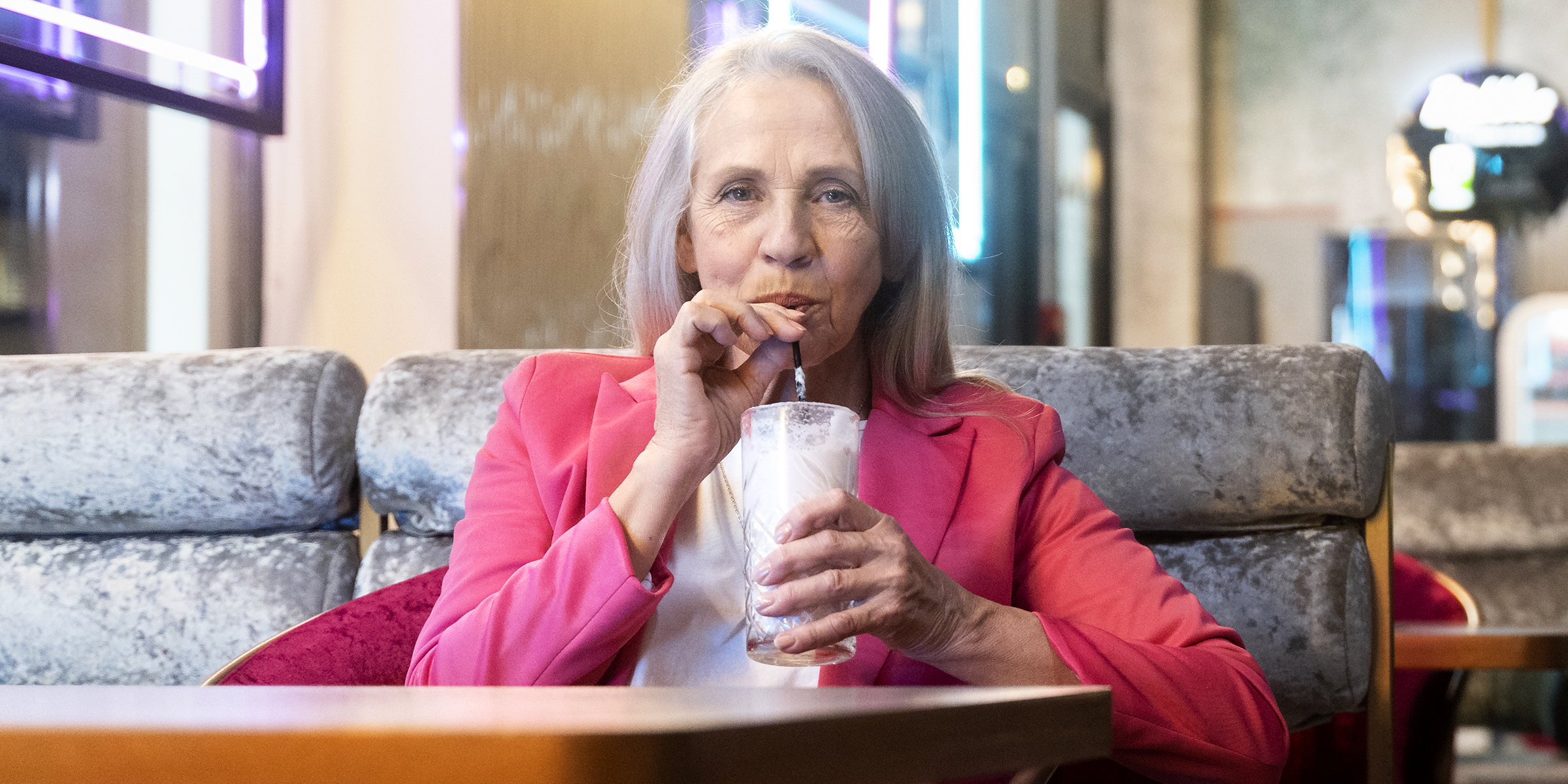 An older woman sitting at a table | Source: Freepik