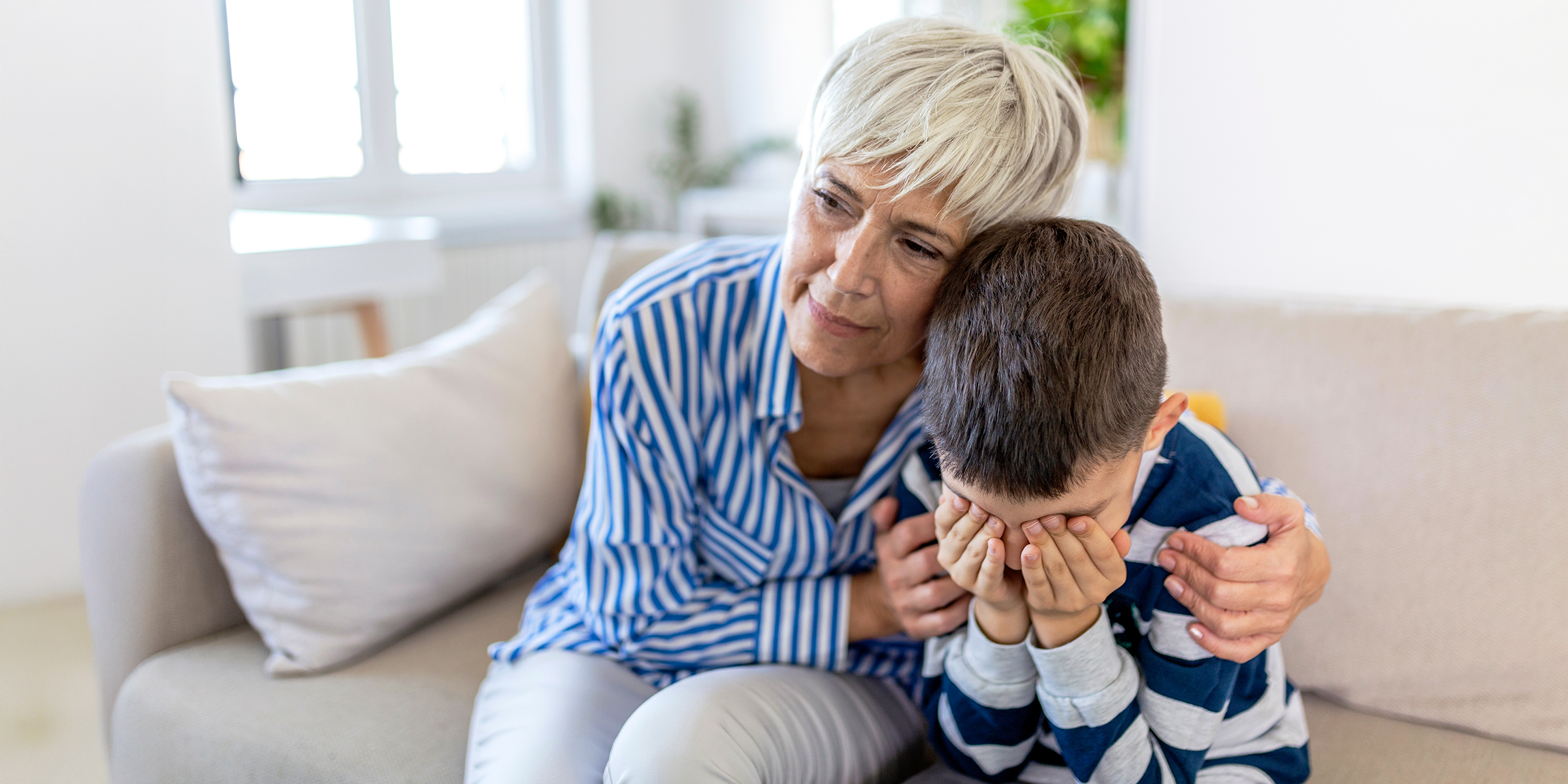 An elderly woman comforting her grandson | Source: Shutterstock