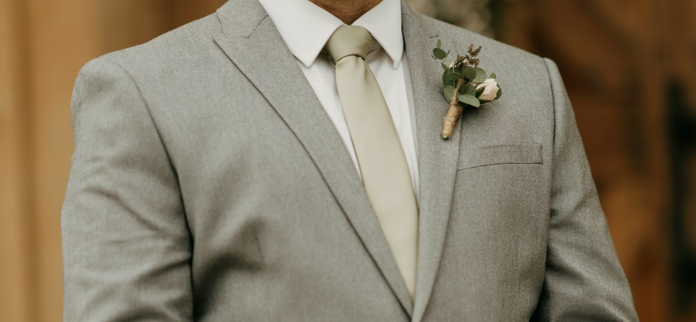 A man in a gray suit with a boutonniere on his lapel | Source: Unsplash