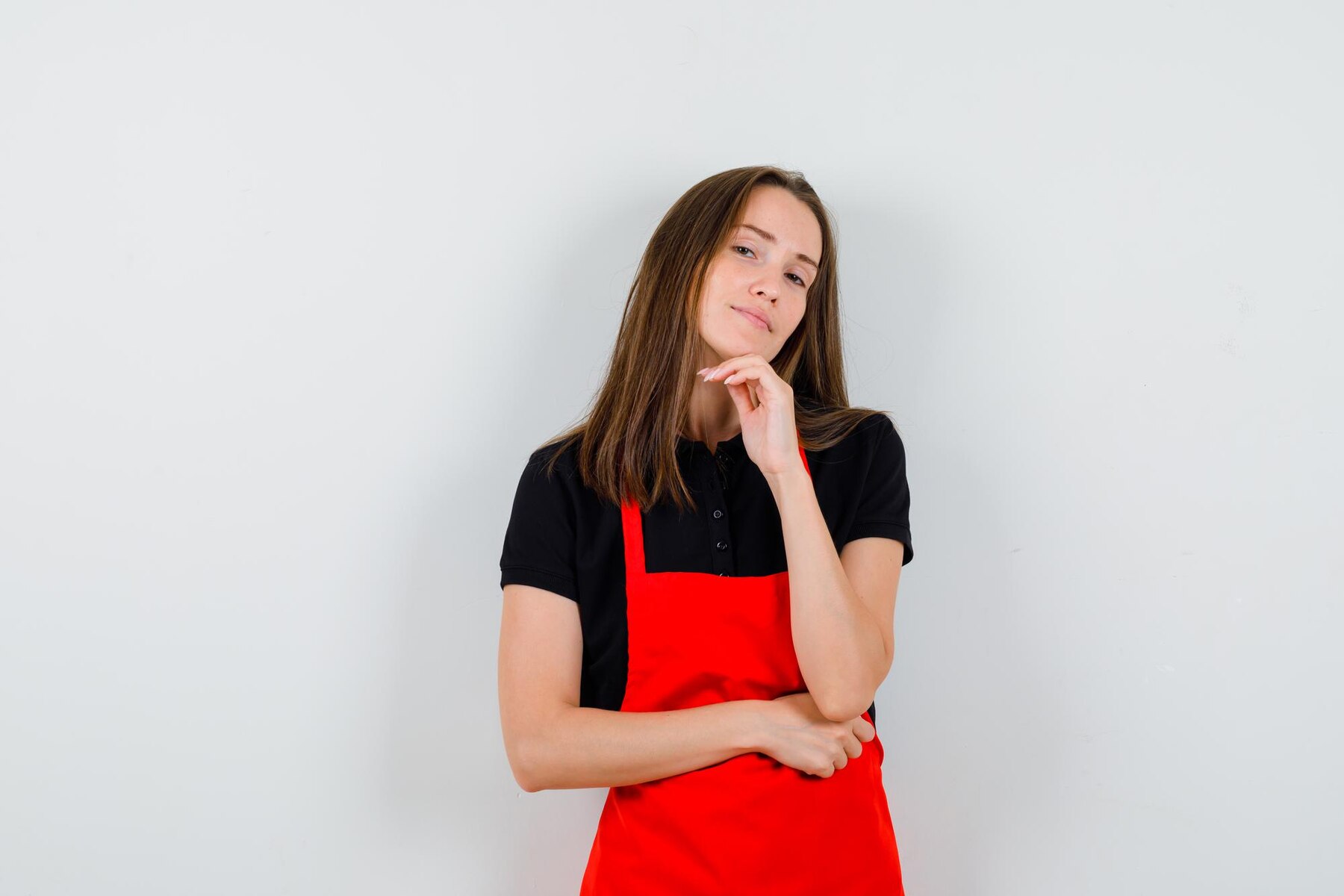 A thoughtful woman in an apron | Source: Freepik