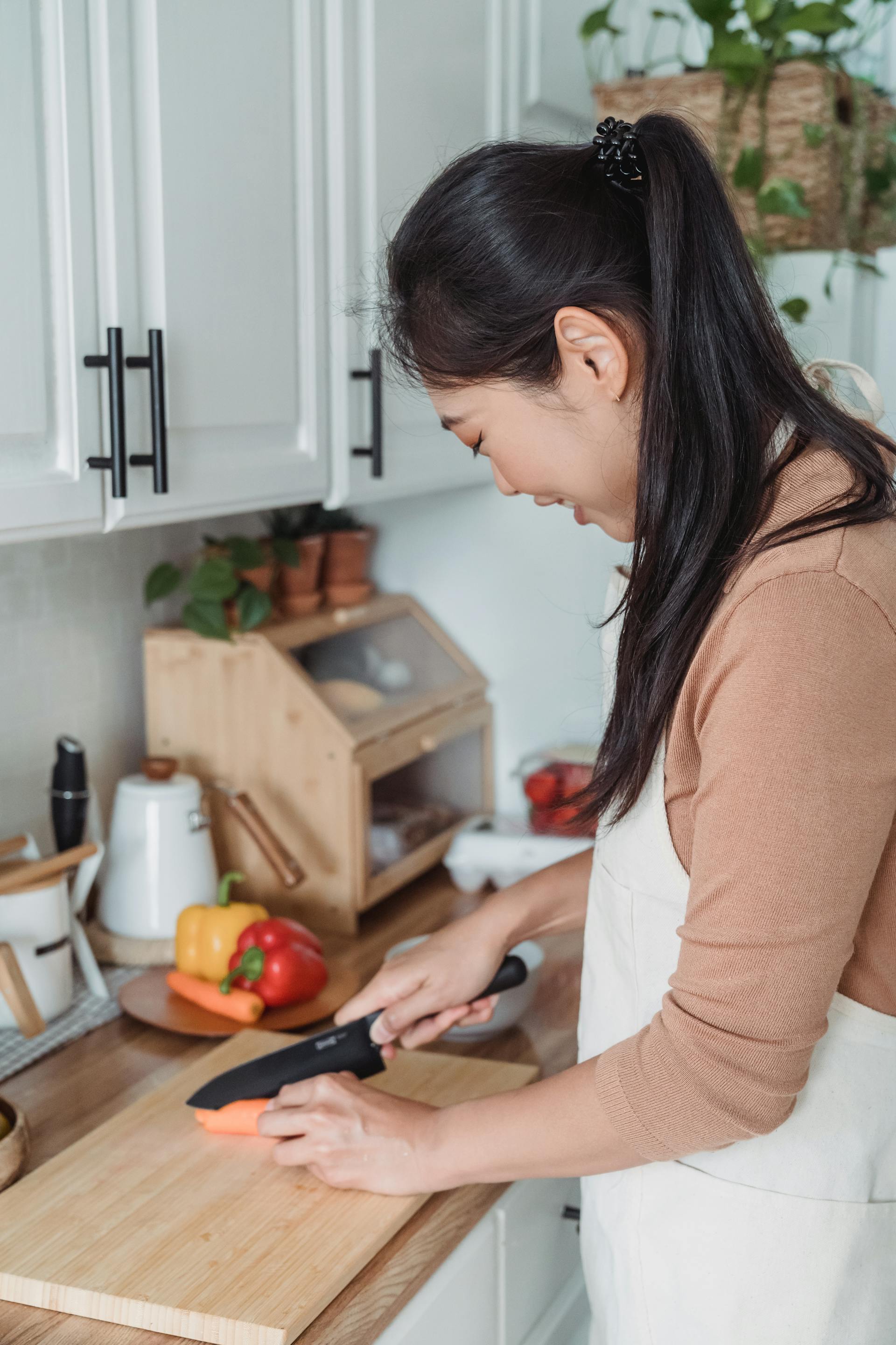 A woman chopping carrots | Source: Pexels