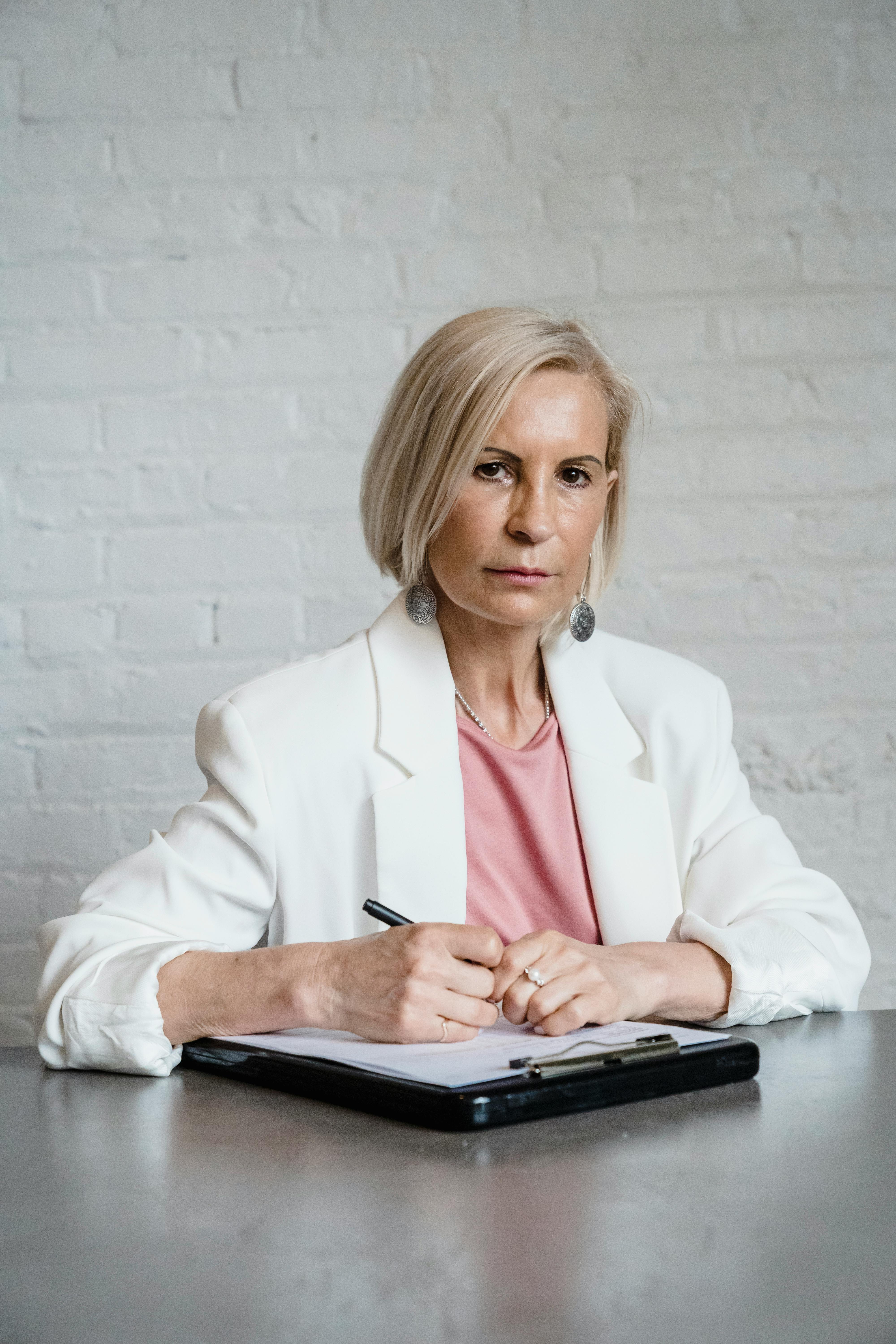 A suspicious woman writing something | Source: Pexels