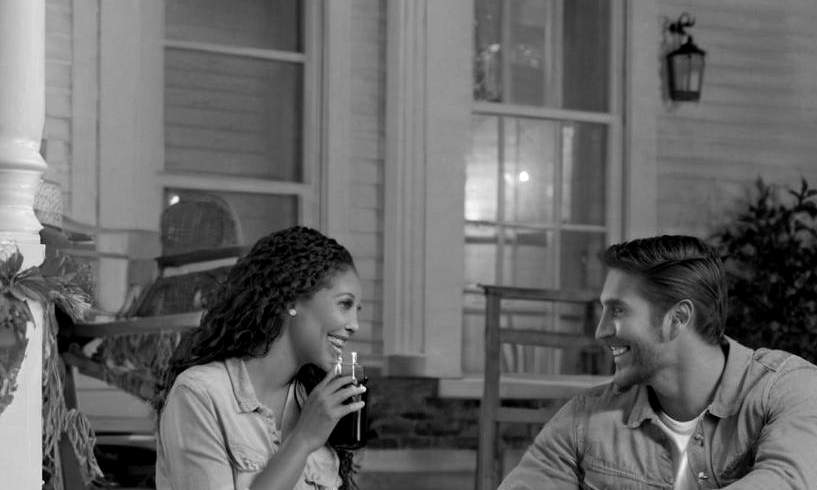 A happy couple conversing on a front porch | Source: Midjourney