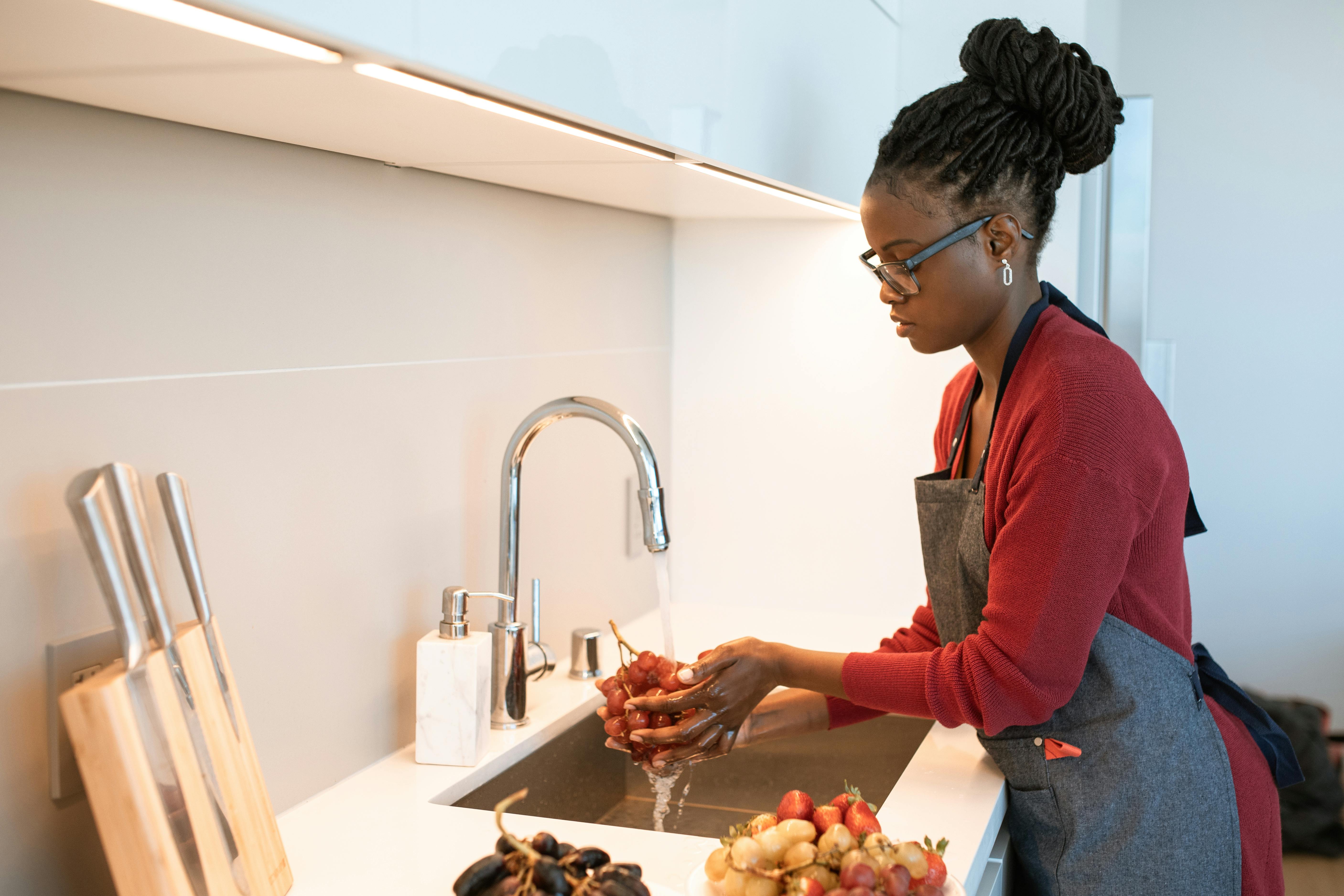 A woman washing fruits at home | Source: Pexels