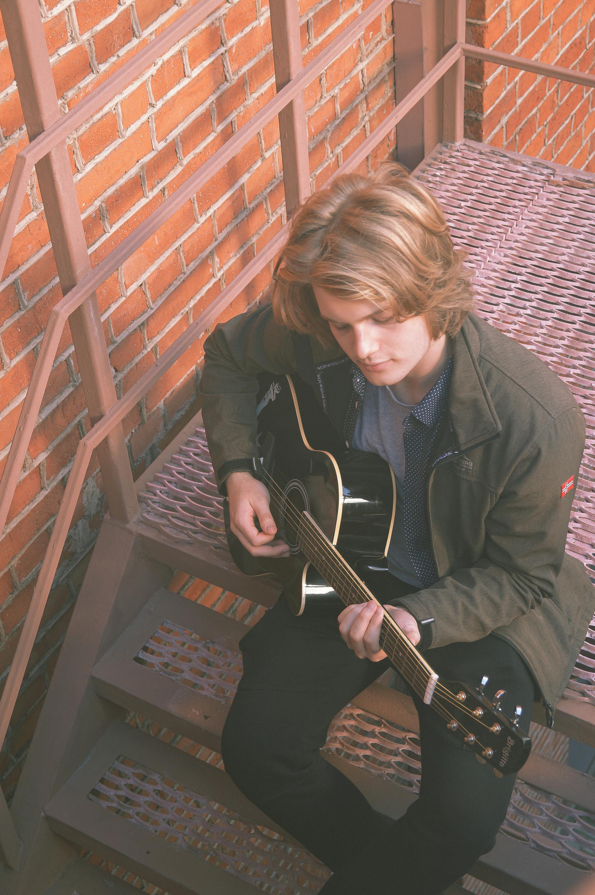 A young man playing a guitar | Source: Pexels