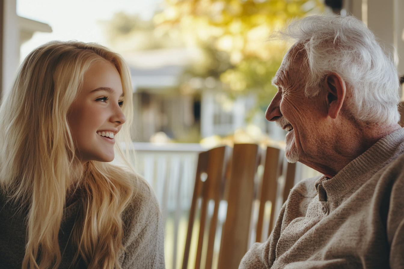 A young woman sitting on a porch with her grandfather | Source: Midjourney