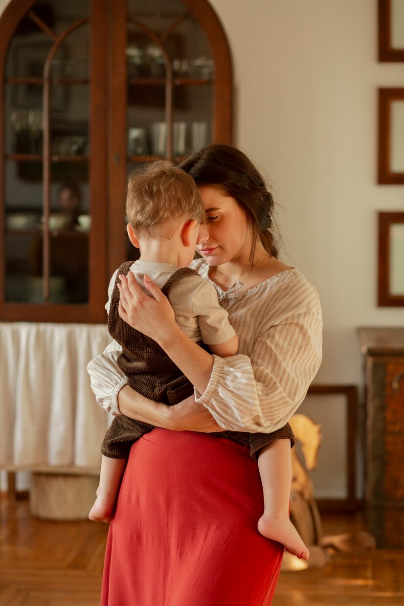 A woman carrying a toddler | Source: Freepik