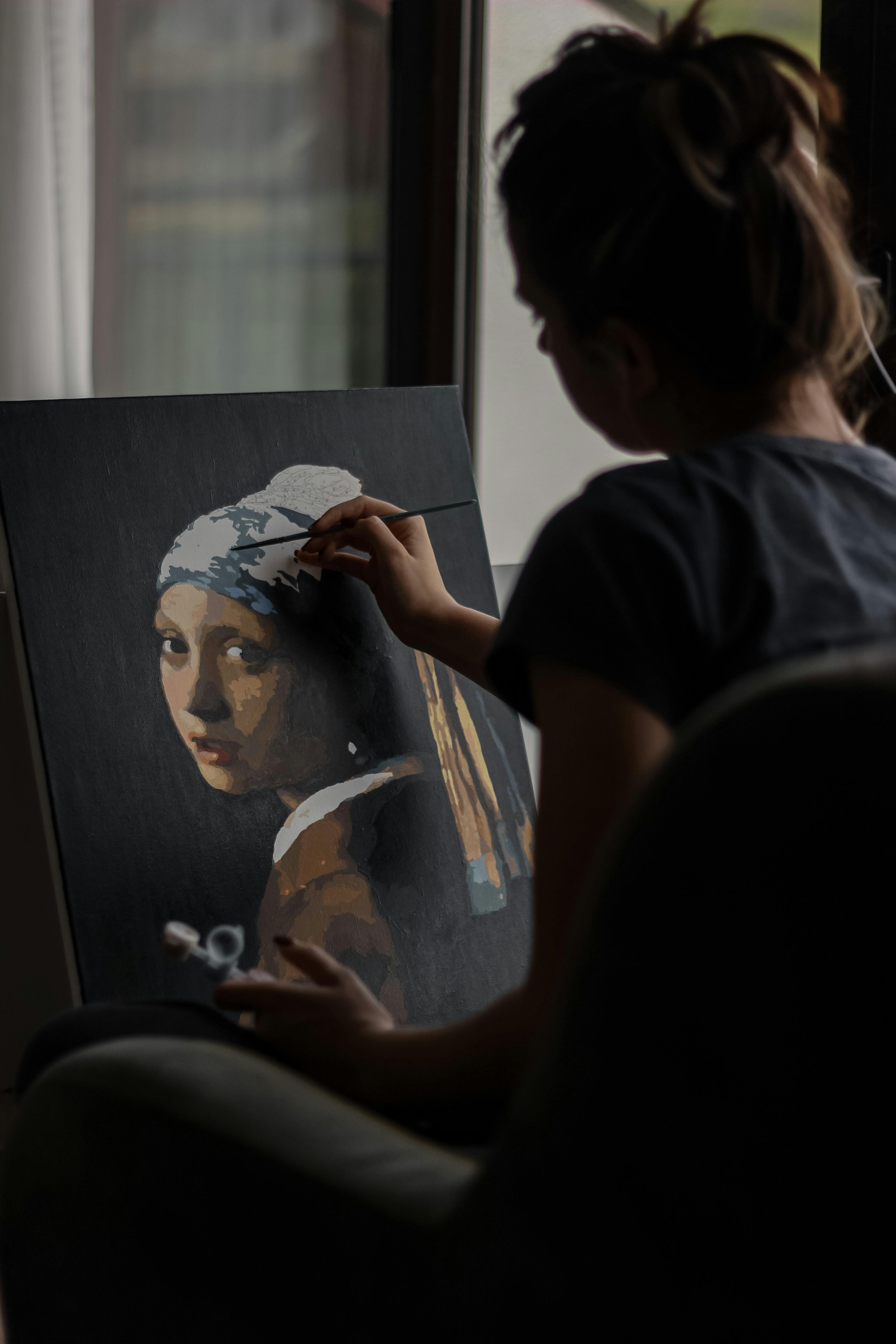 A woman painting her version of "Girl with a Pearl Earring" | Source: Pexels