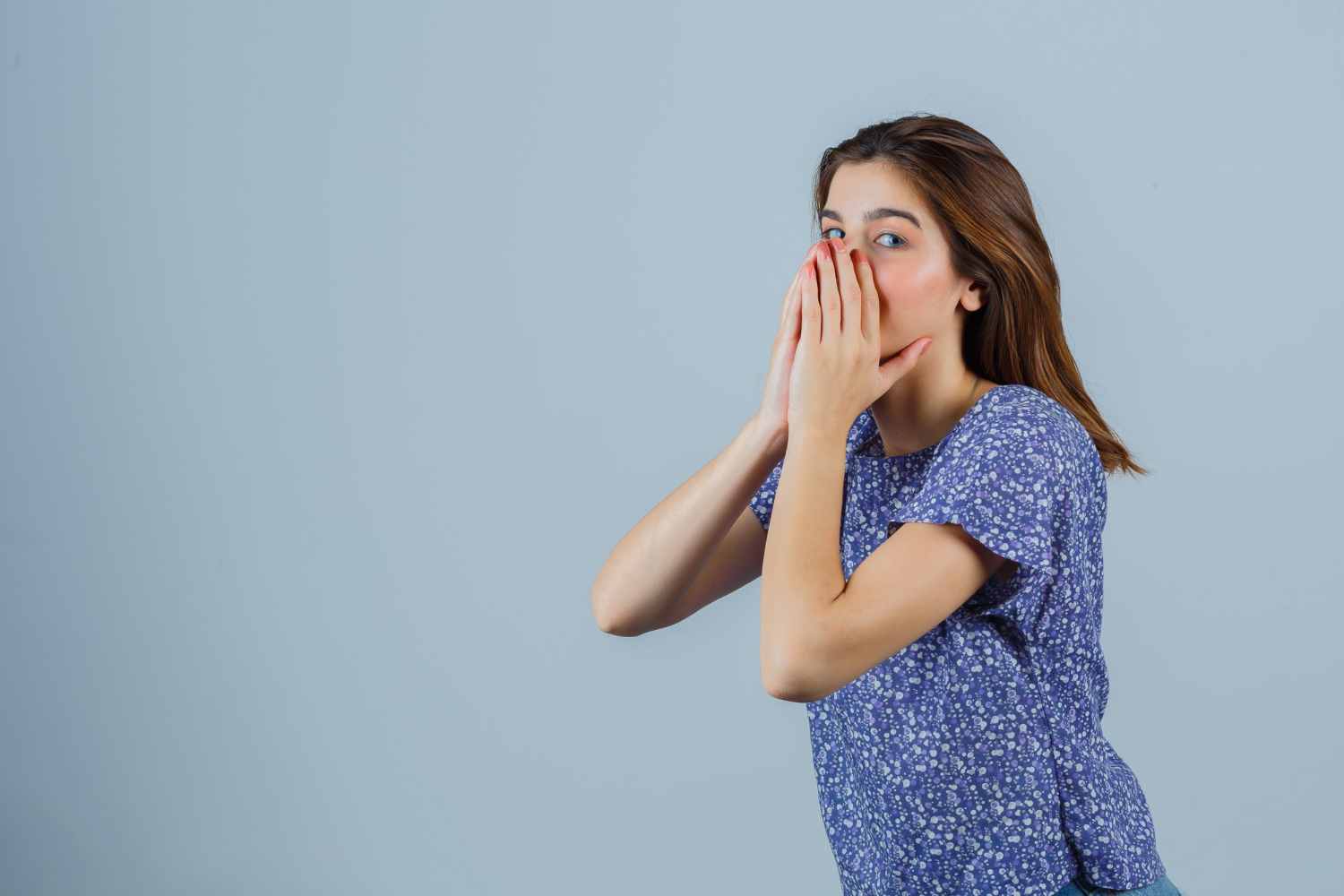 A stunned woman covering her mouth | Source: Freepik