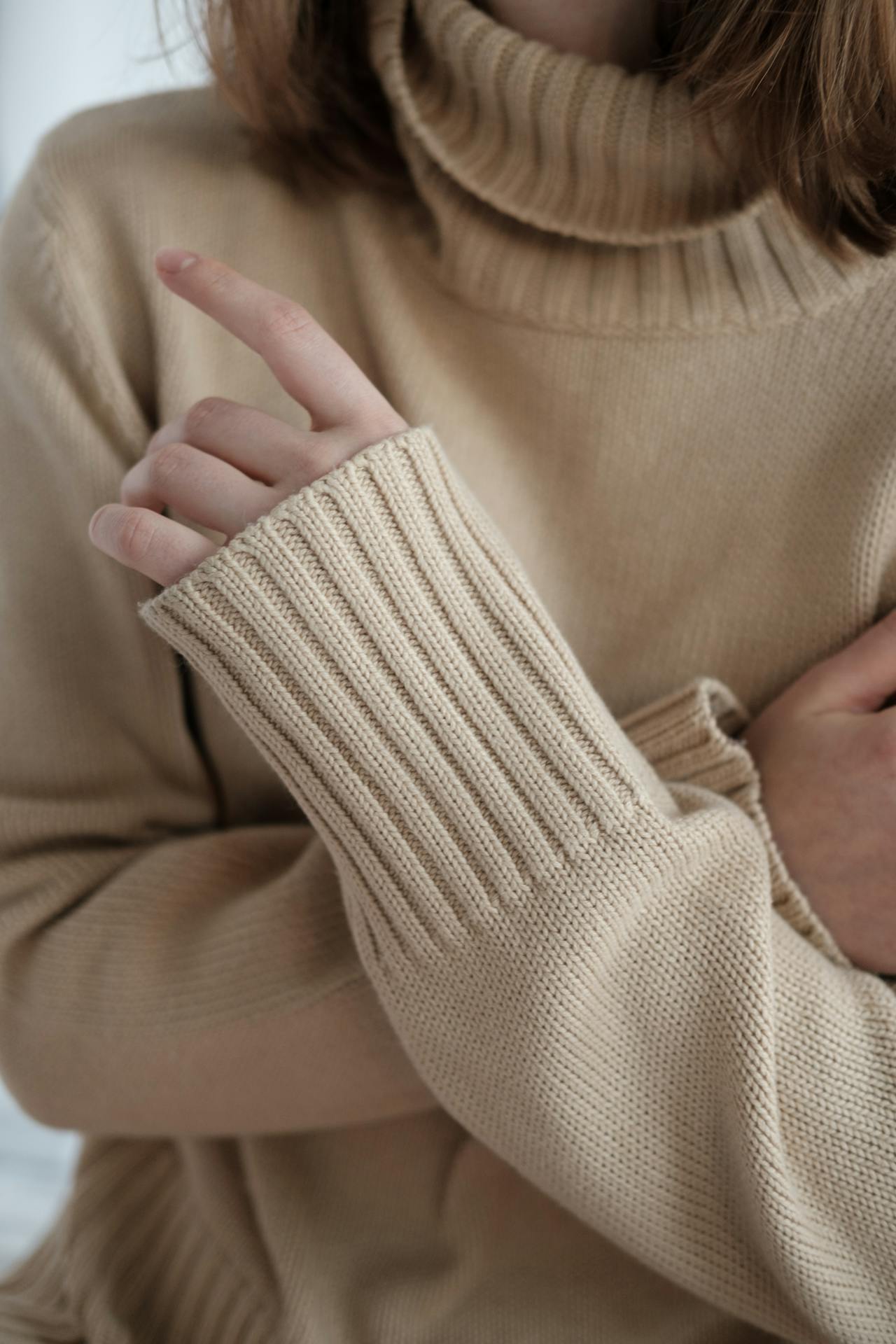 A woman crossing her arms and pointing her finger at someone | Source: Pexels