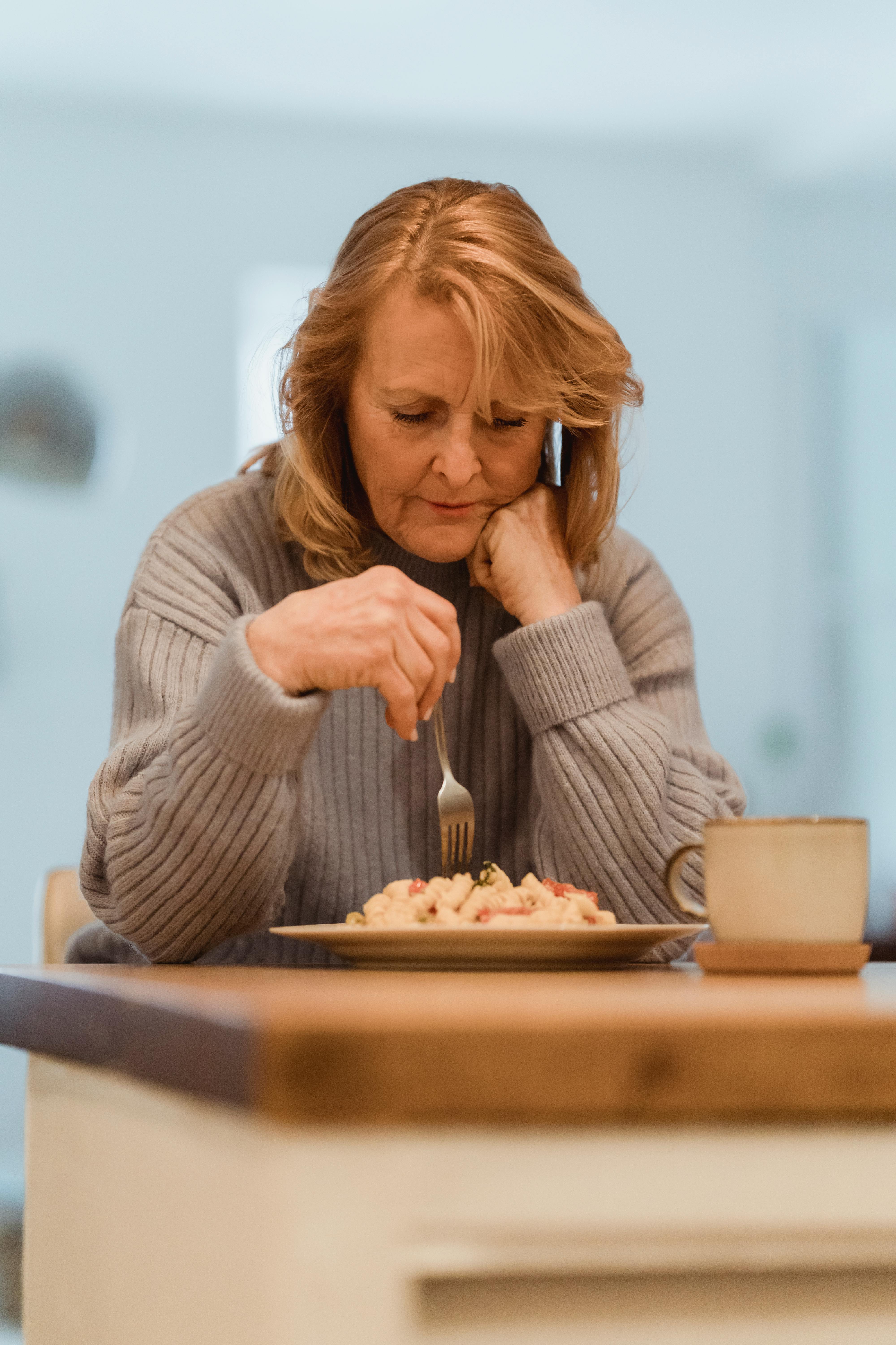An annoyed woman sitting in the dining room | Source: Pexels