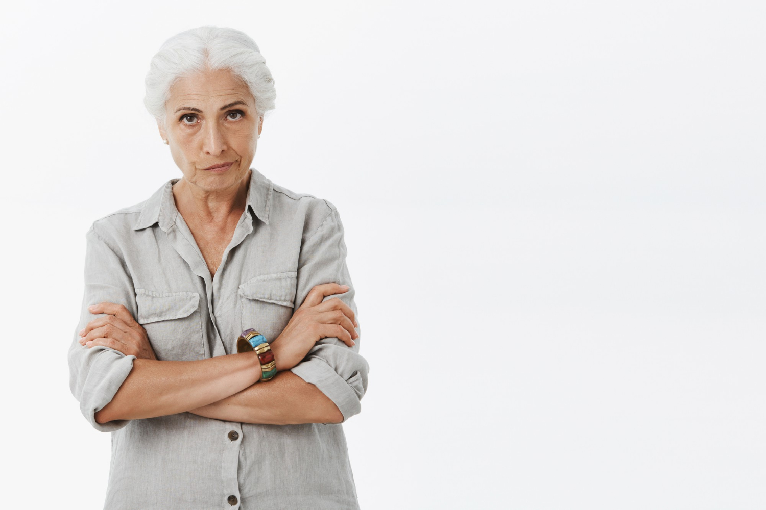 A displeased older woman crossing her arms and staring | Source: Freepik