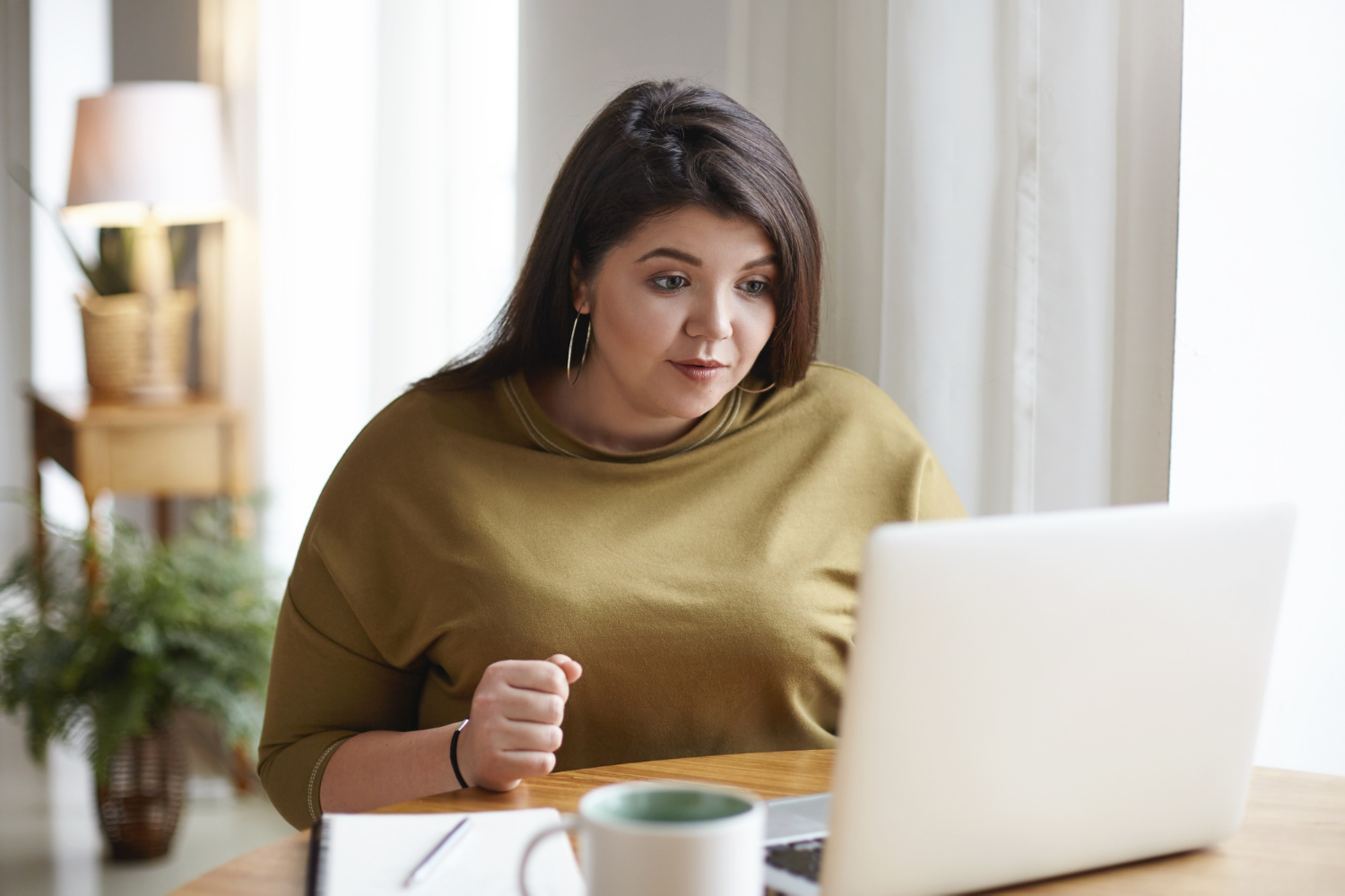 A delighted woman looking at her laptop | Source: Freepik