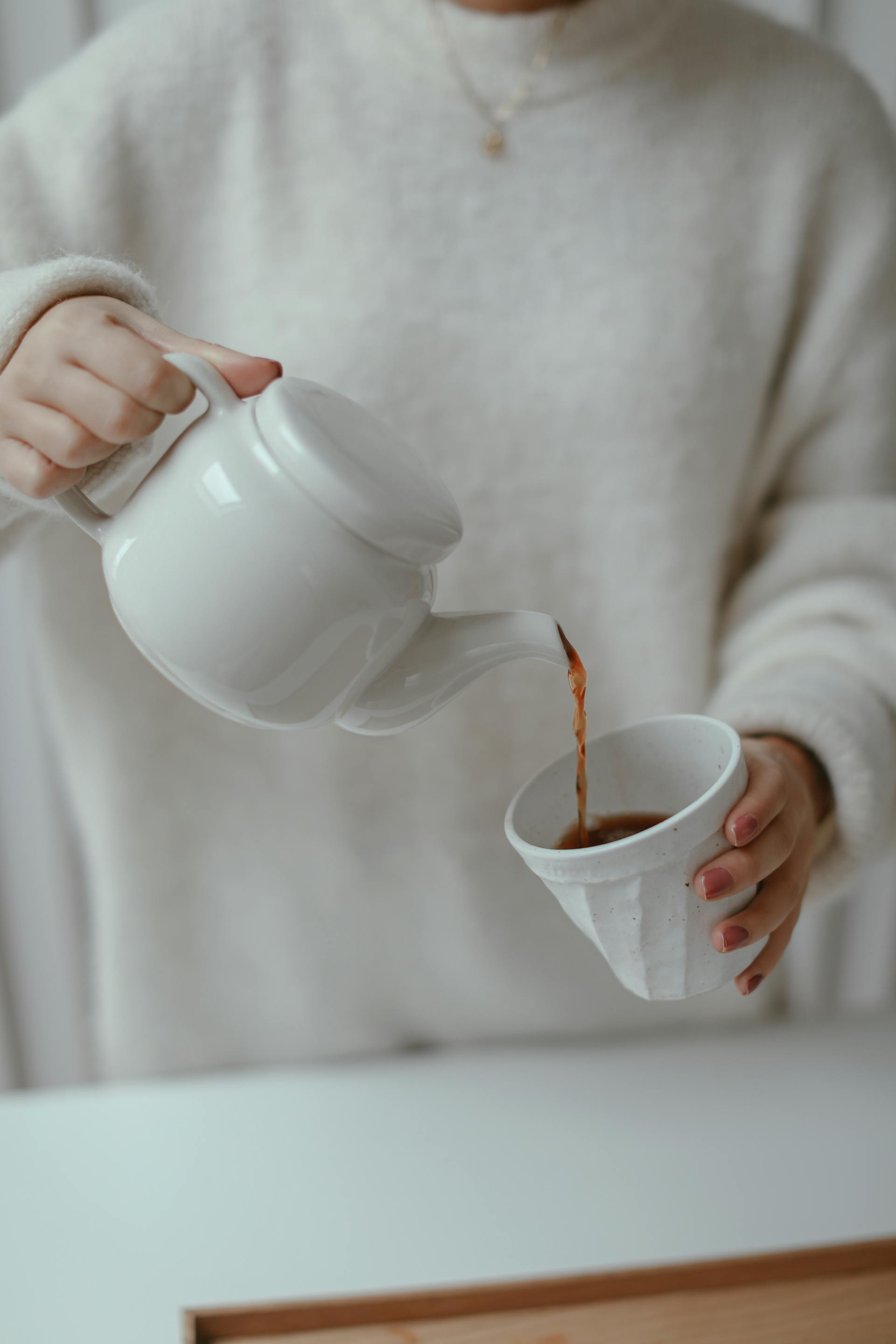A close-up shot of a person pouring tea in a cup | Source: Pexels