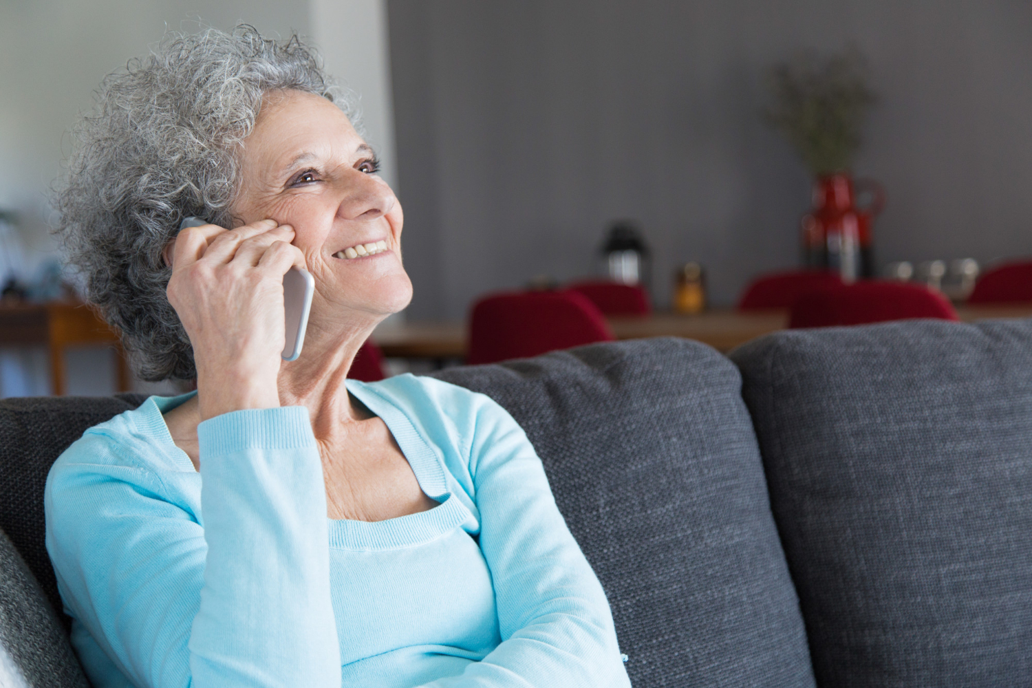 A delighted senior woman talking on the phone | Source: Freepik