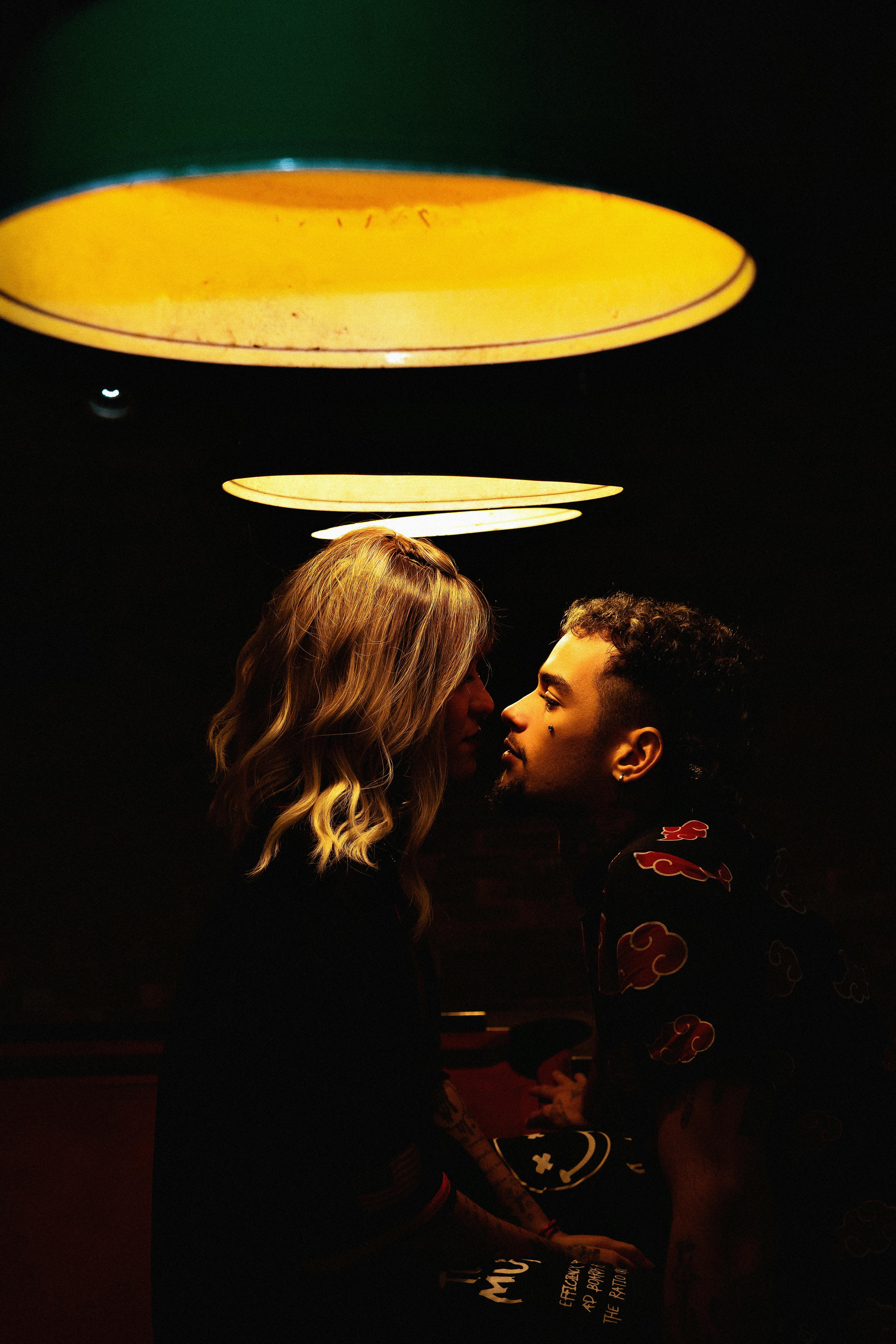 A young man and woman kissing under the lights | Source: Pexels