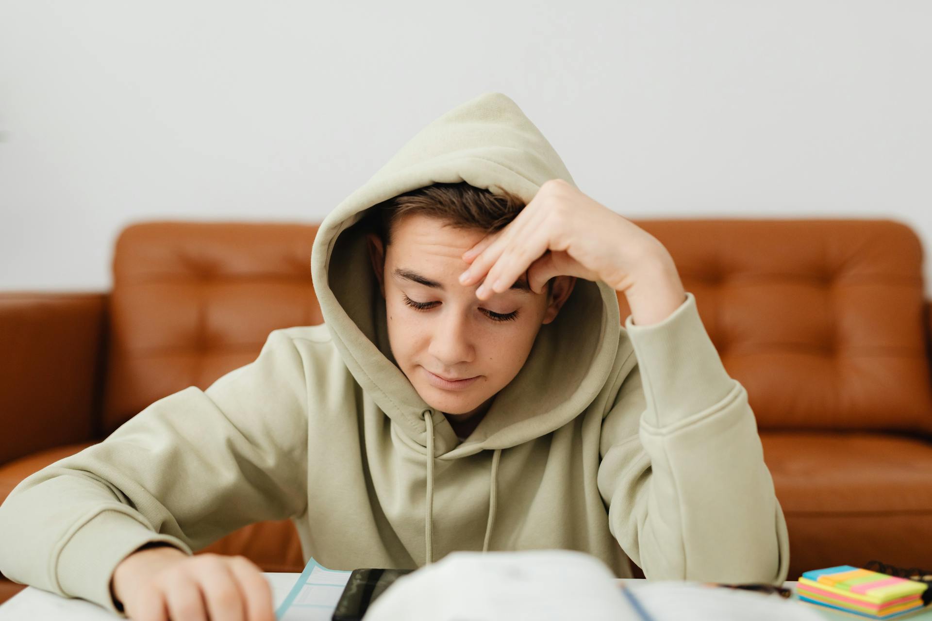 A teenage boy doing homework | Source: Pexels