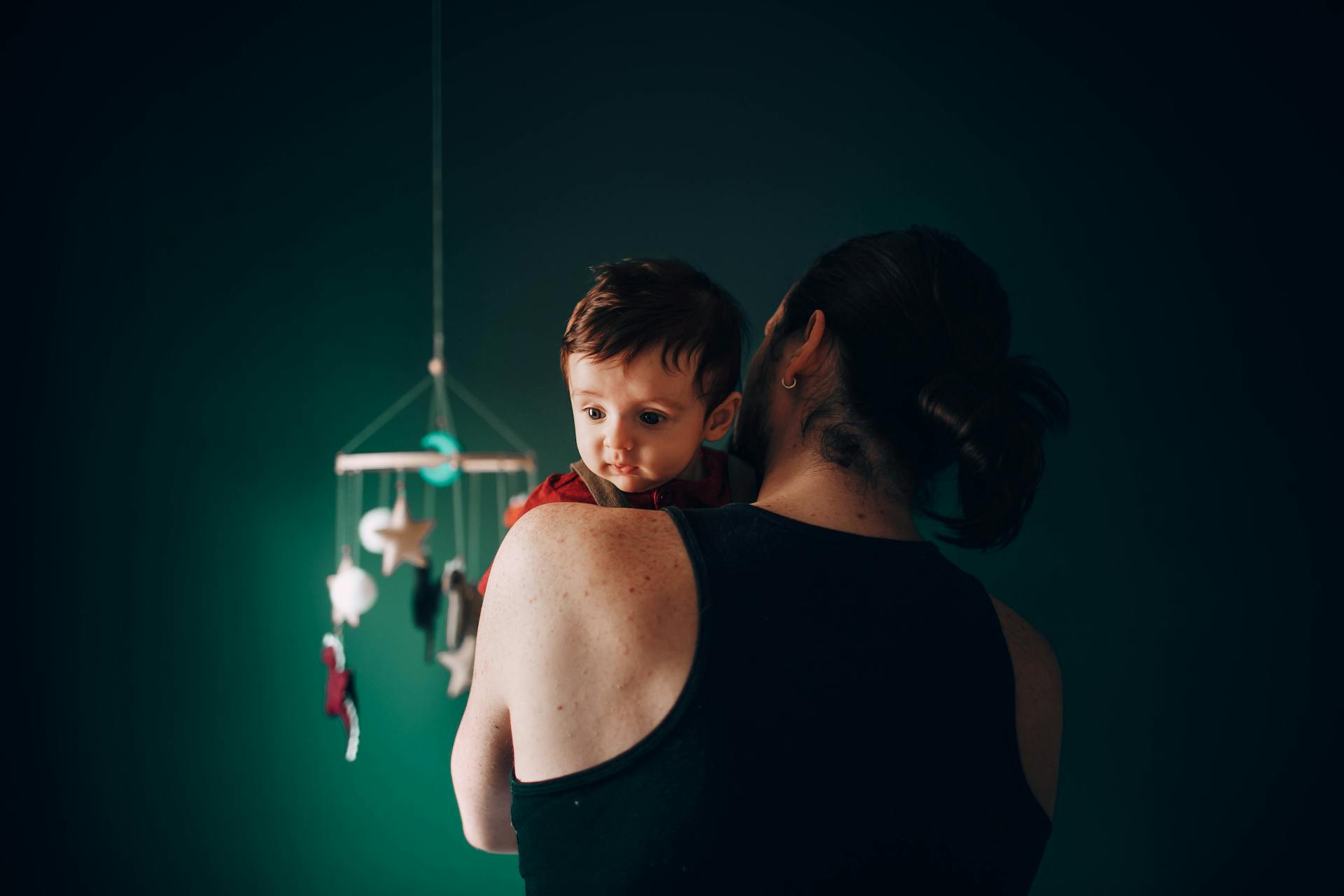 A man rocking a baby in a nursery | Source: Pexels