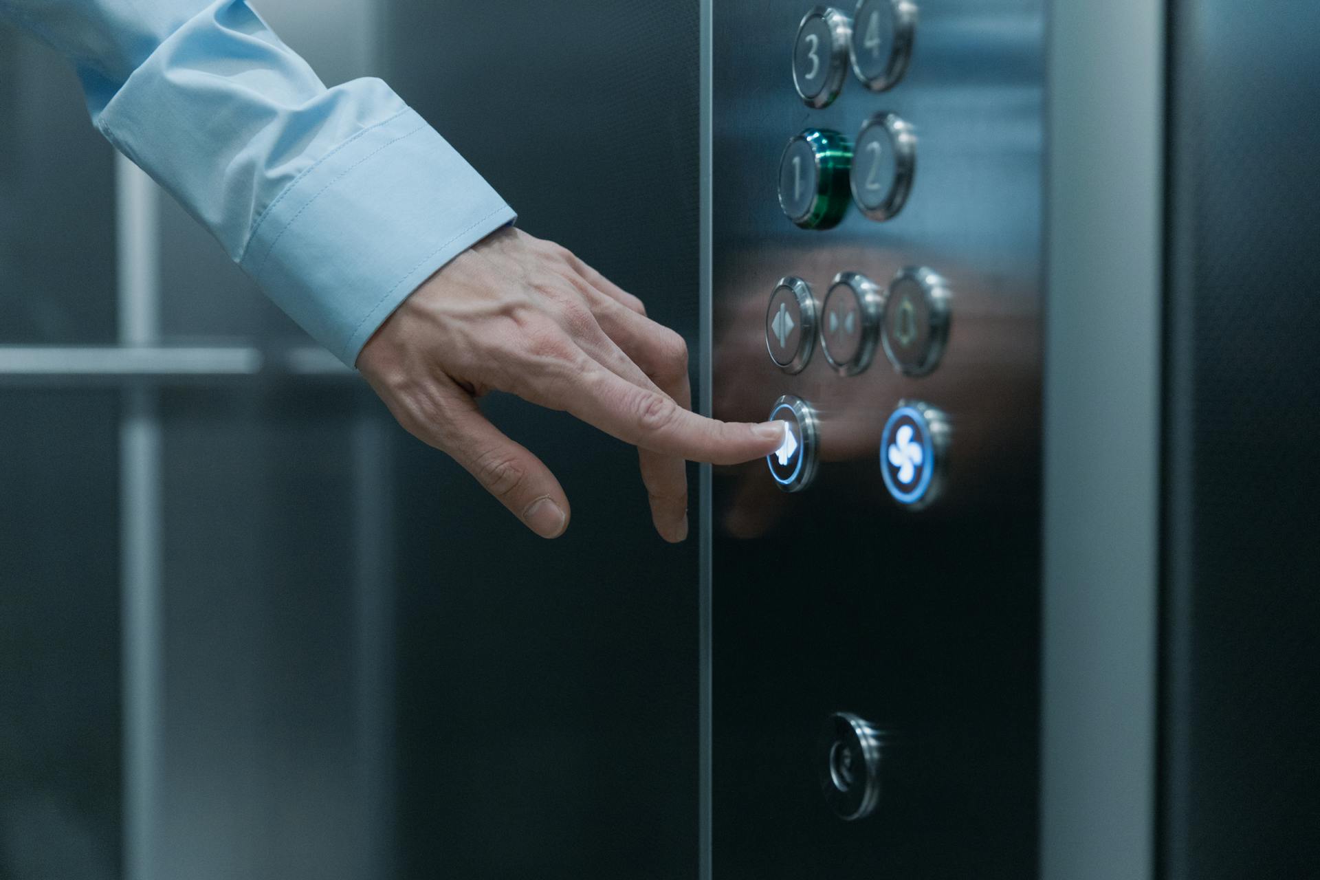 A man's finger pressing an elevator button | Source: Pexels