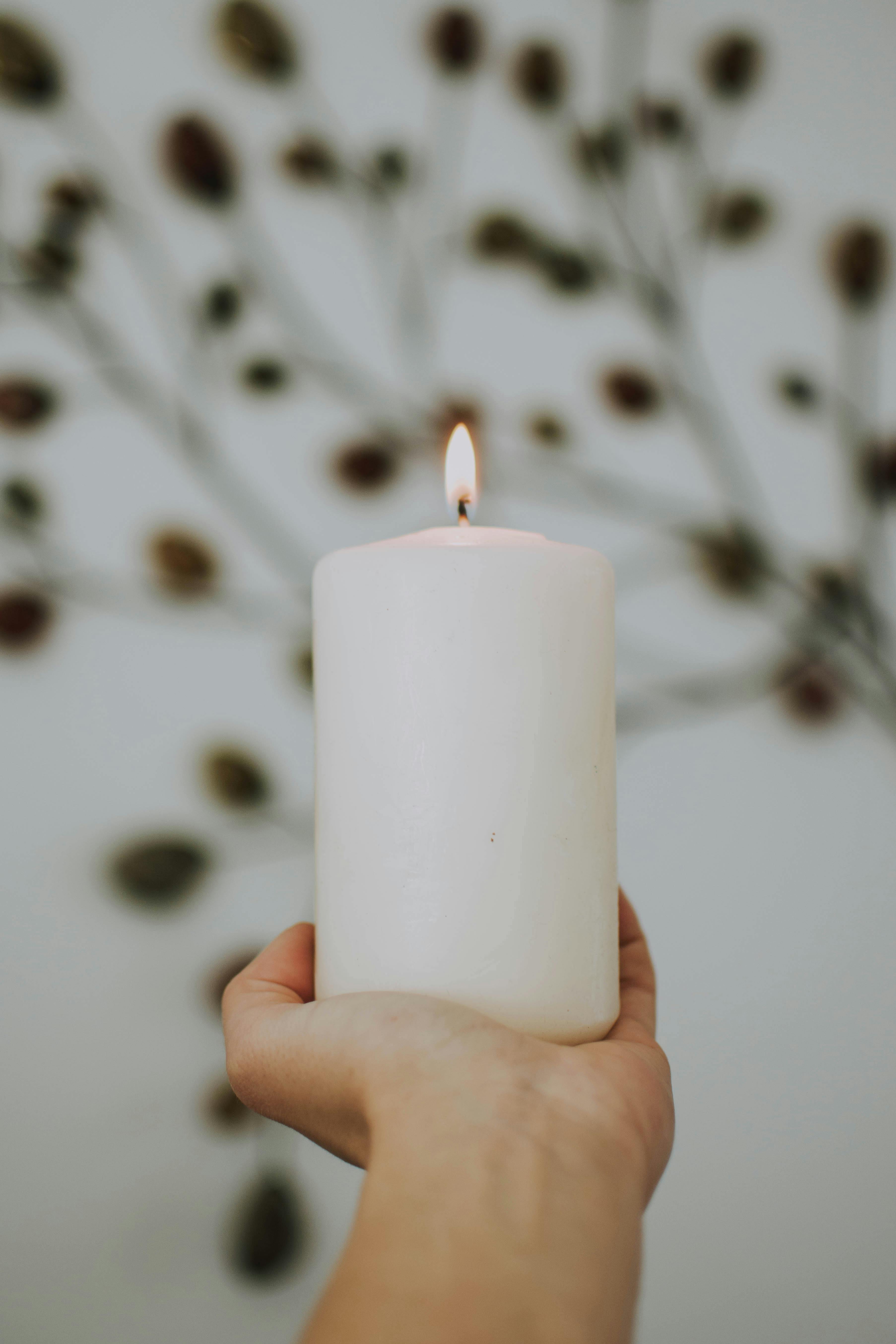 A hand holding up a lit candle | Source: Pexels