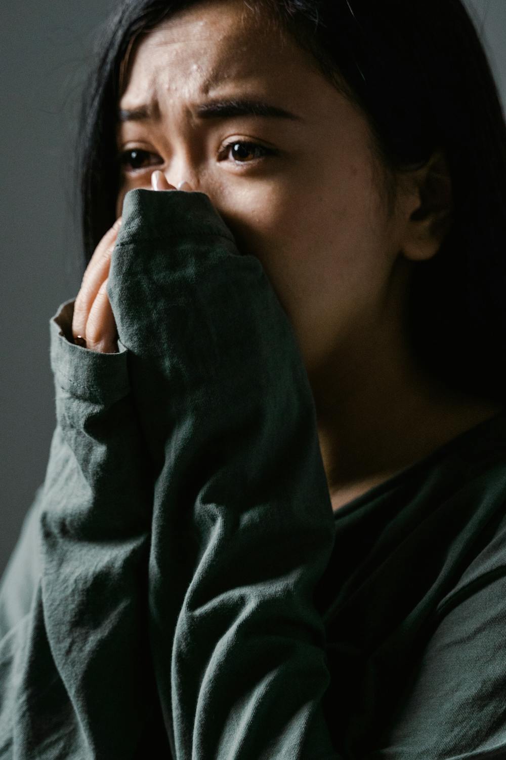 A scared woman covering her mouth ⏐ Source: Pexels