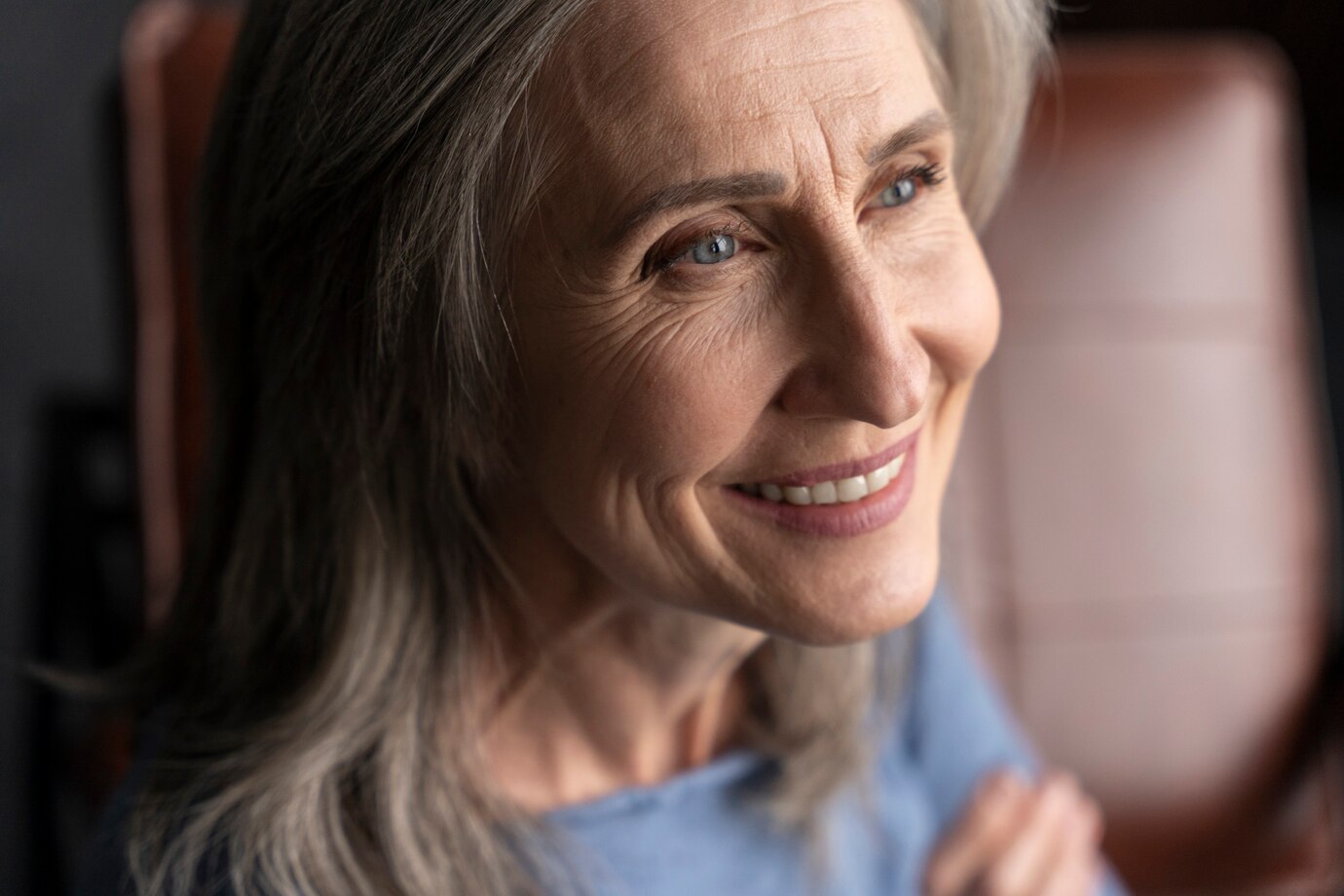 A smiling elderly woman looking to her side | Source: Freepik