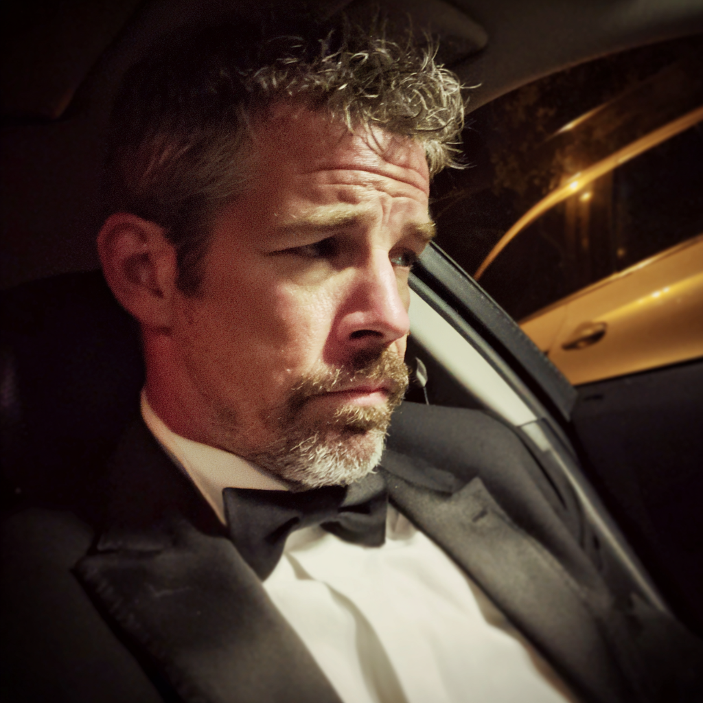 A man wearing a tux and sitting in a car | Source: Midjourney