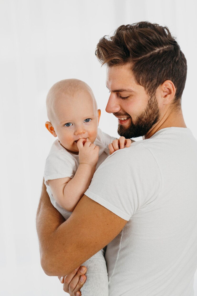 A man holding a baby | Source: Freepik